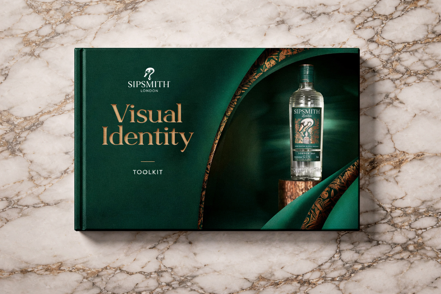 The image shows a green-colored toolkit box titled 'Visual Identity Toolkit' from SipSmith London, with a bottle of gin on a copper pedestal inside a partially open window on the box, set on a marble surface.