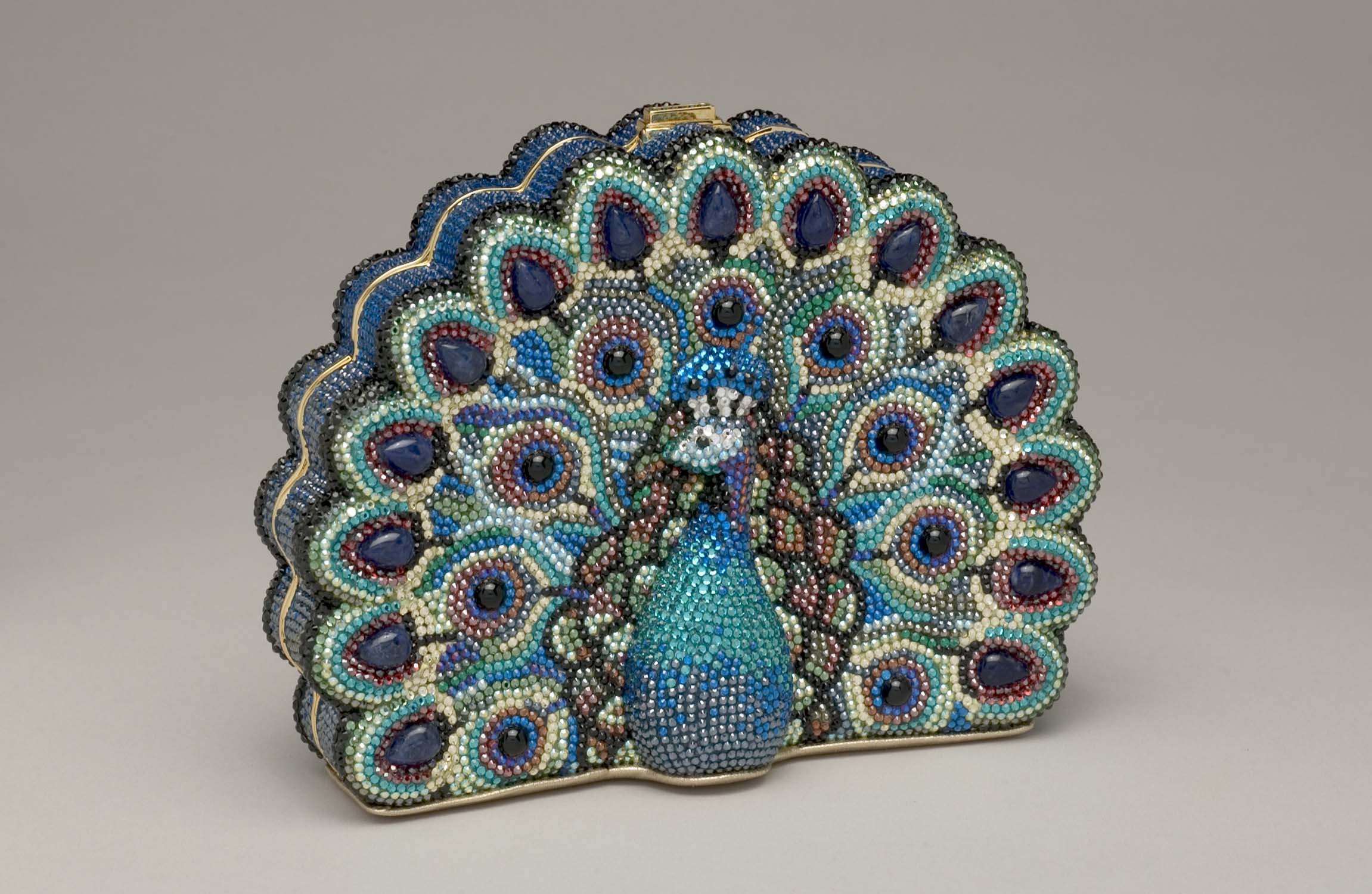 Peacock-shaped handbag decorated with multicolored beads, featuring a feathered tail design.