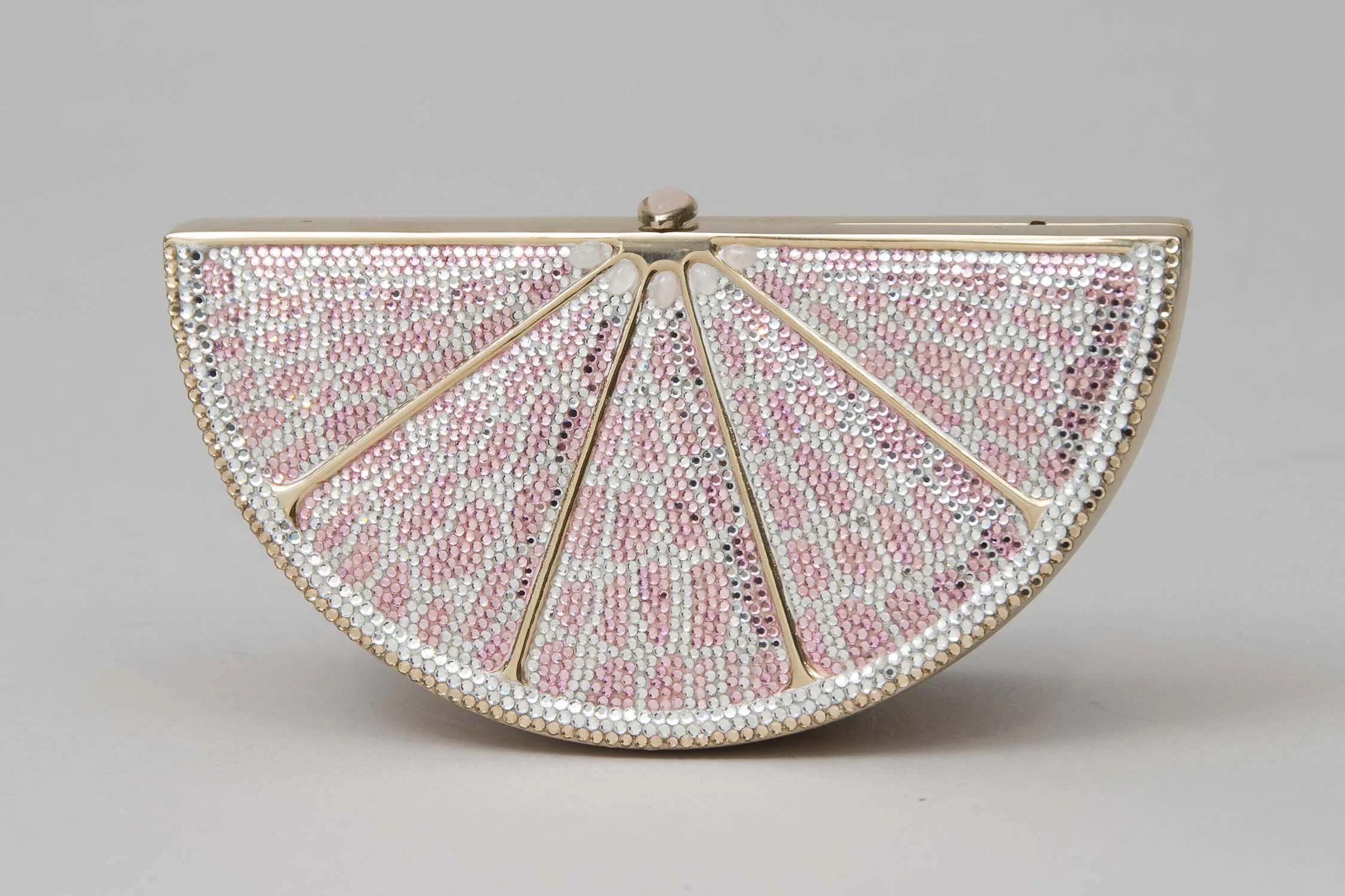 A slice of grapefruit clutch purse by the famous handbag designer Judith Leiber decorated with pink and white rhinestones.