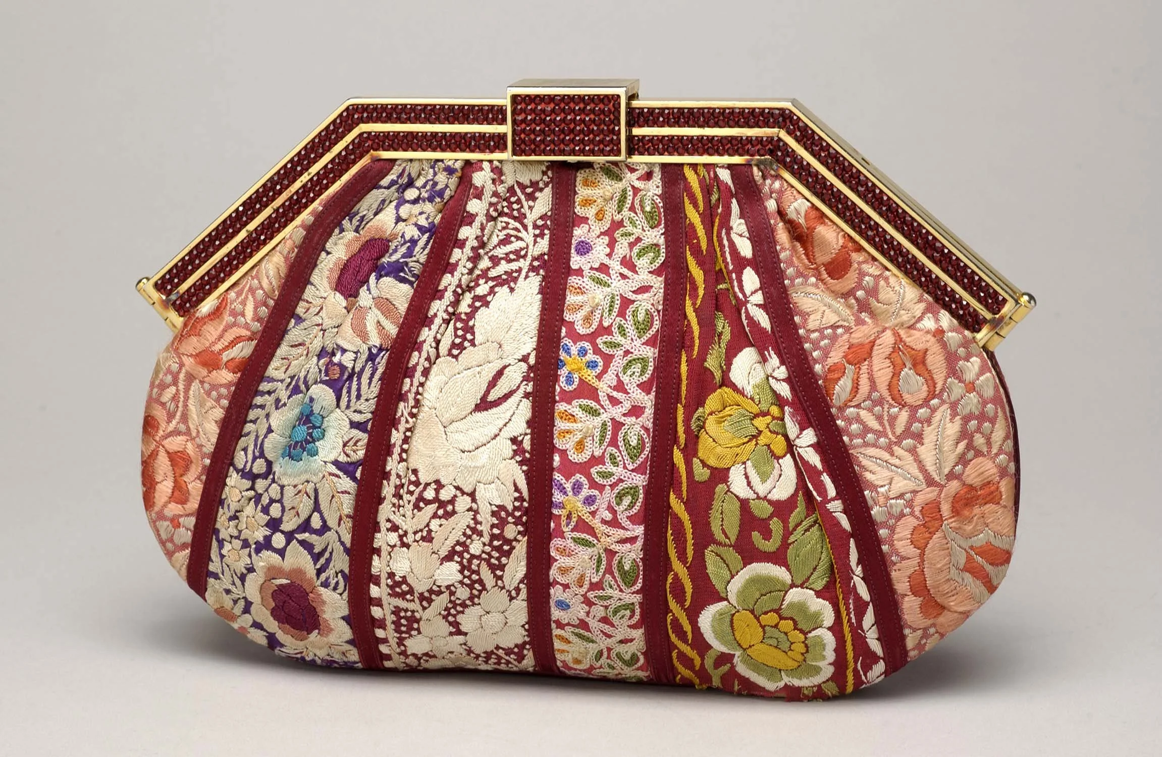 A handbag with intricate floral embroidery and a gold frame clasp by Judith Leiber.