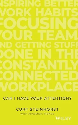 Book cover with yellow background and bold text about working habits and focus, titled 'Can I Have Your Attention?' by Curt Steinhorst with Jonathan McKee, published by Wiley.