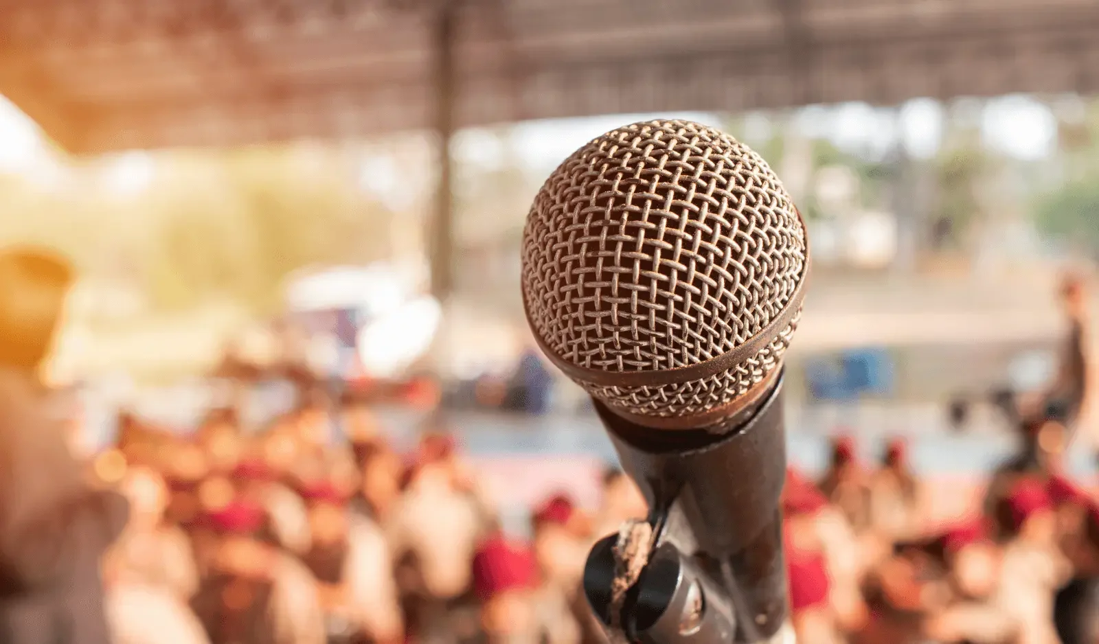 Microphone on stage facing an audience, representing hypnotherapy for public speaking and performance anxiety