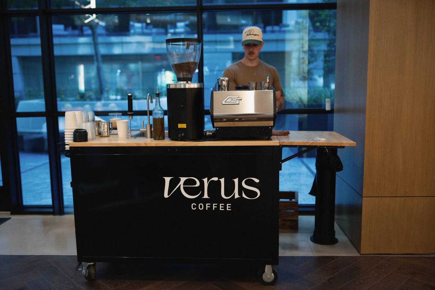 Verus branded black coffee cart with a barista and espresso equipment