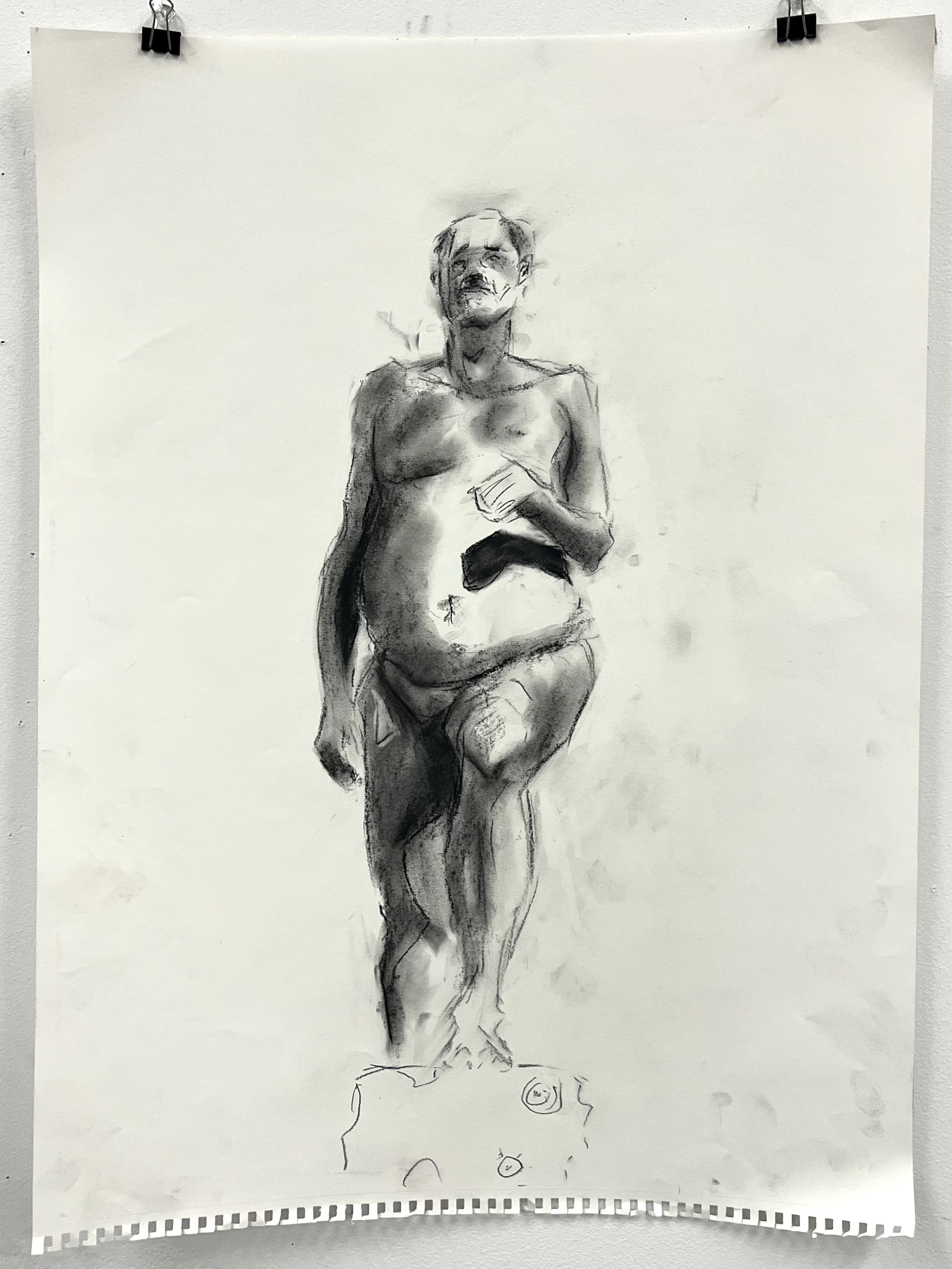 A grayscale sketch of a standing nude man with one leg raised, holding a small object in his hand, with a rough outline of a base or pedestal beneath him.