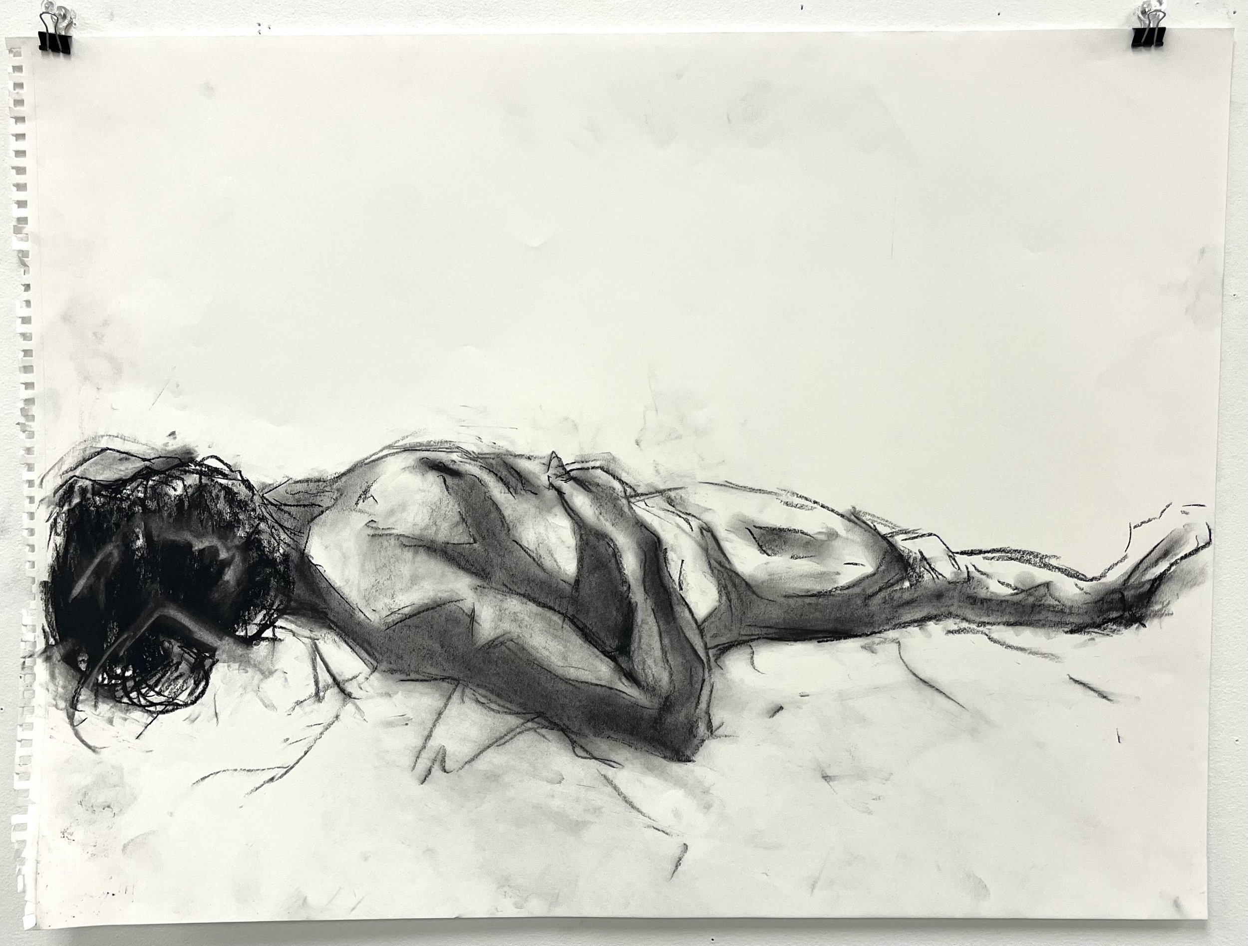 A black and white sketch of a nude woman lying on her side with her head resting on her arm.