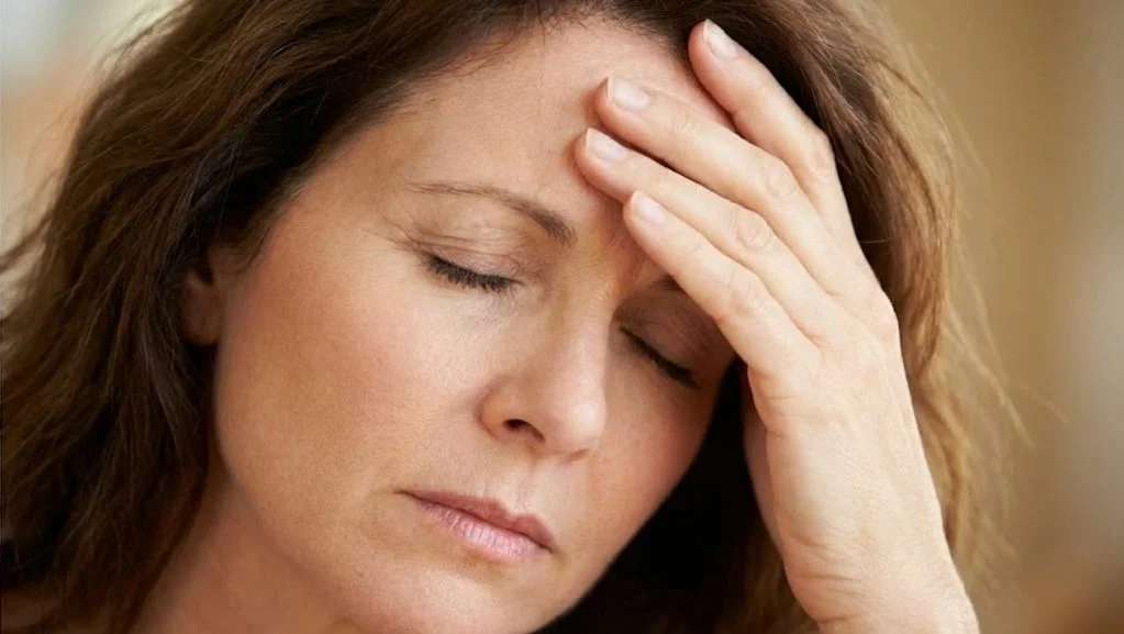 A woman in Boulder seeking relief from menopause symptoms like brain fog, fatigue, and hot flashes through expert HRT.
