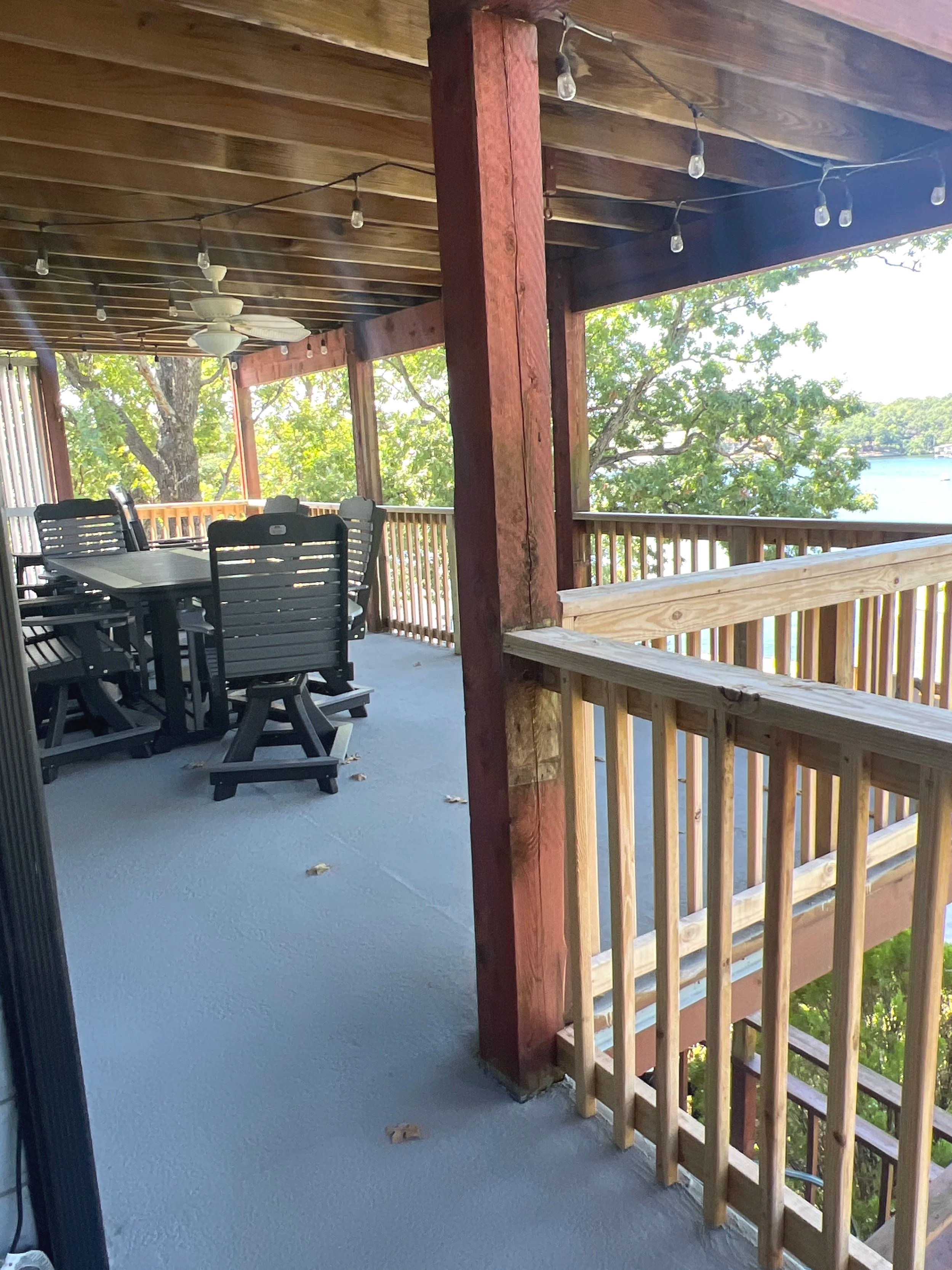 (Before) Unpainted structural beams and handrails on a Linn Creek patio before Quality Control Painting's finish.