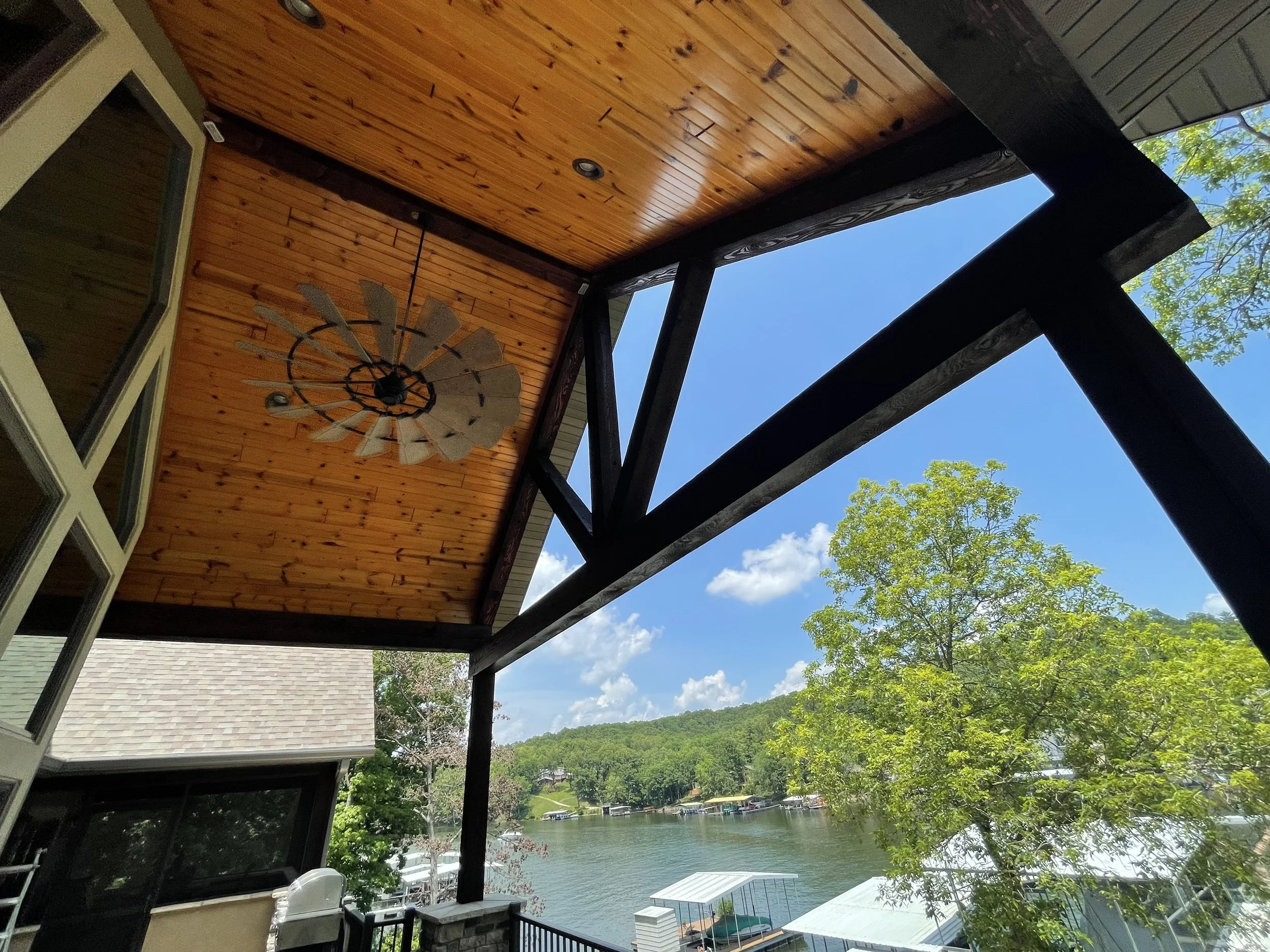 Luxury porch ceiling featuring professional wood staining and crisp paint lines by Quality Control Painting in Osage Beach.