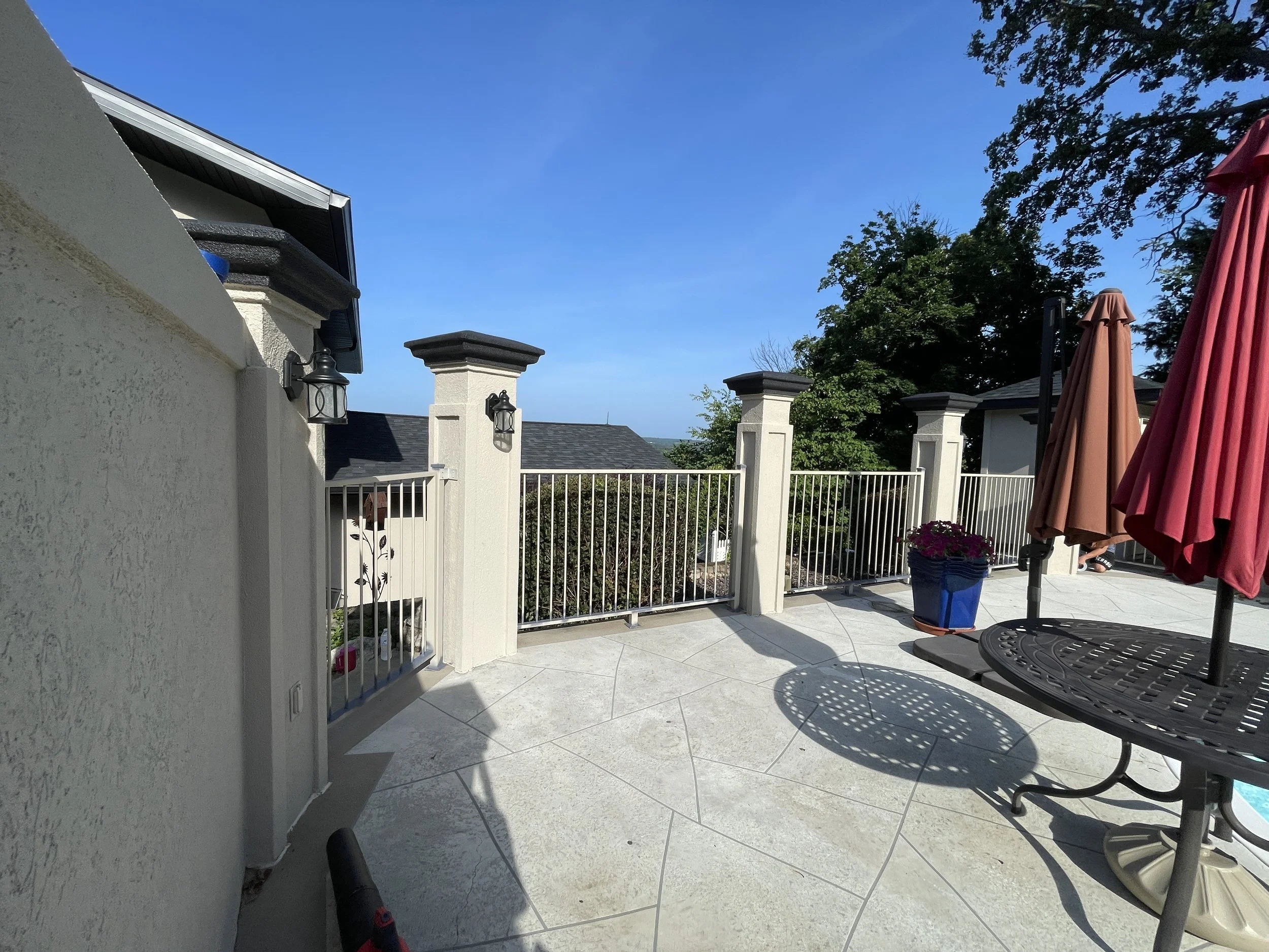 Cream masonry pillars with charcoal caps painted by Quality Control Painting for a poolside patio in Osage Beach.