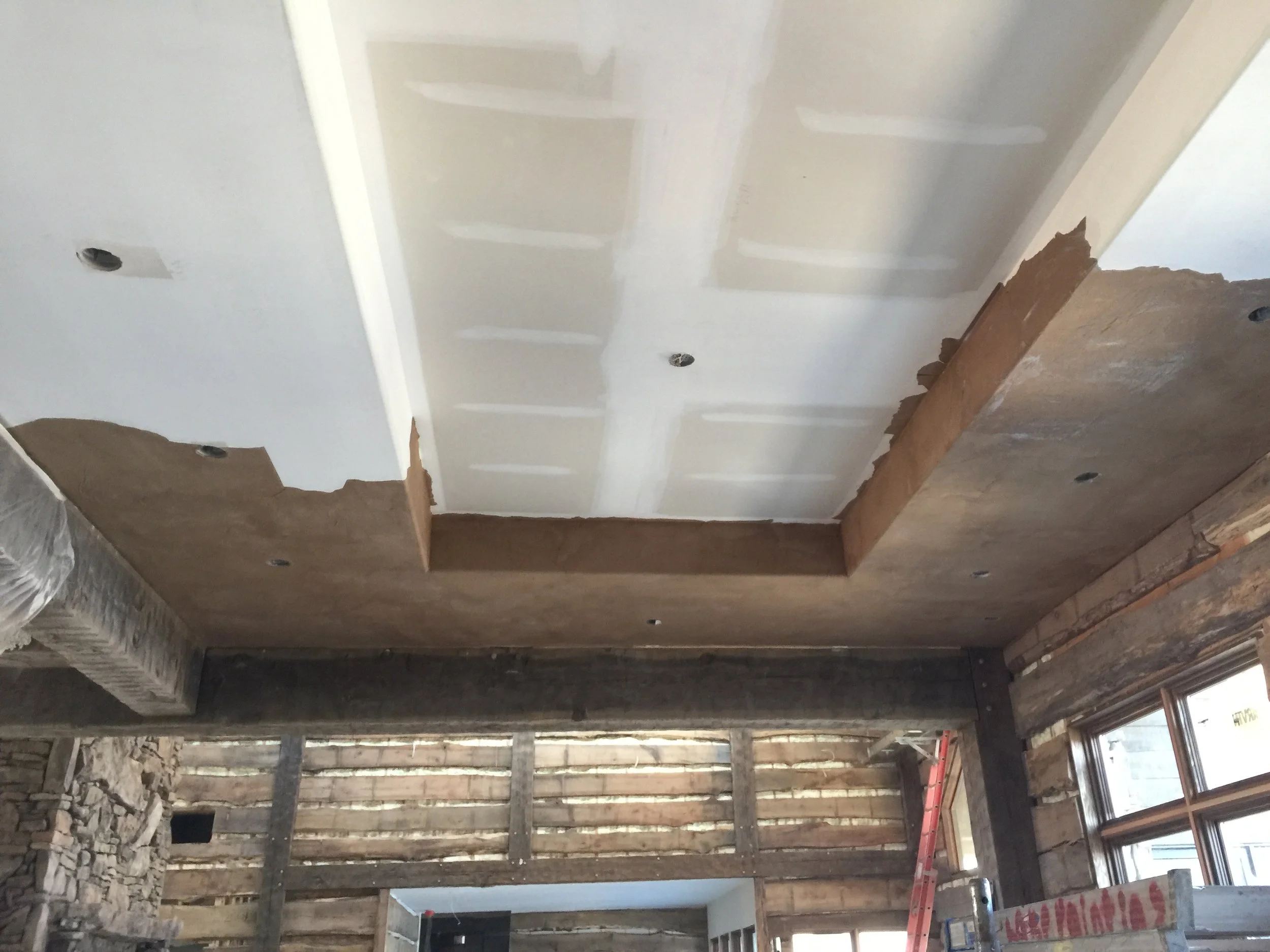 Quality Control Painting performing drywall finishing and mudding around rustic ceiling beams in a Gravois Mills cabin.