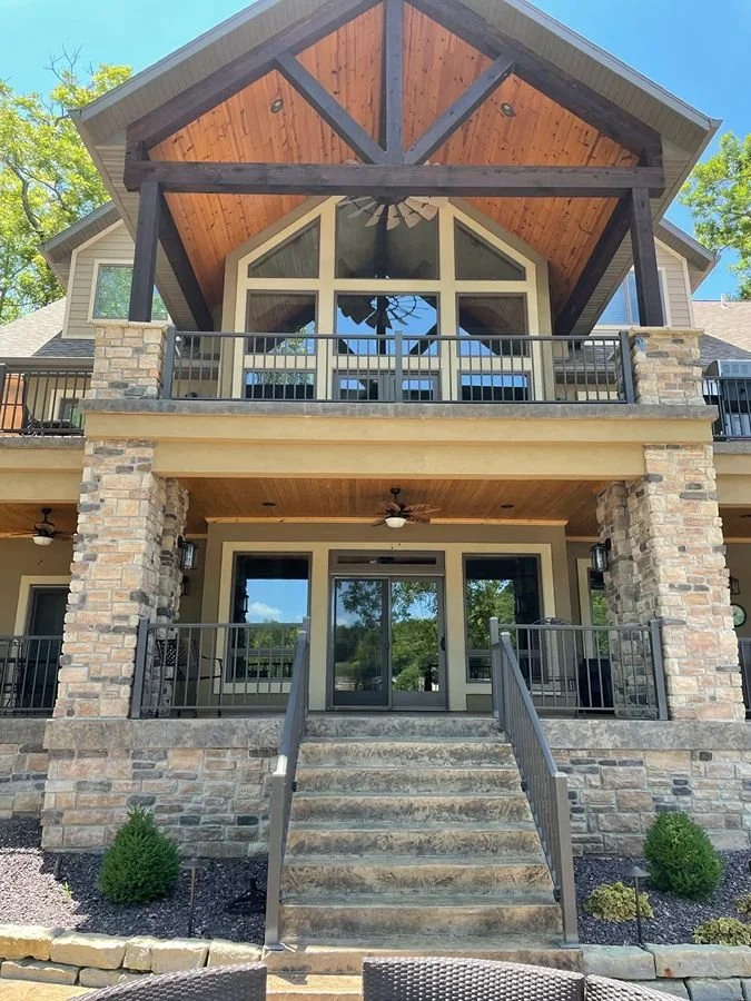 Full luxury exterior restoration by Quality Control Painting in the Lake of the Ozarks area, featuring custom stained cedar ceilings, dark timber beams, and professionally painted masonry and trim.