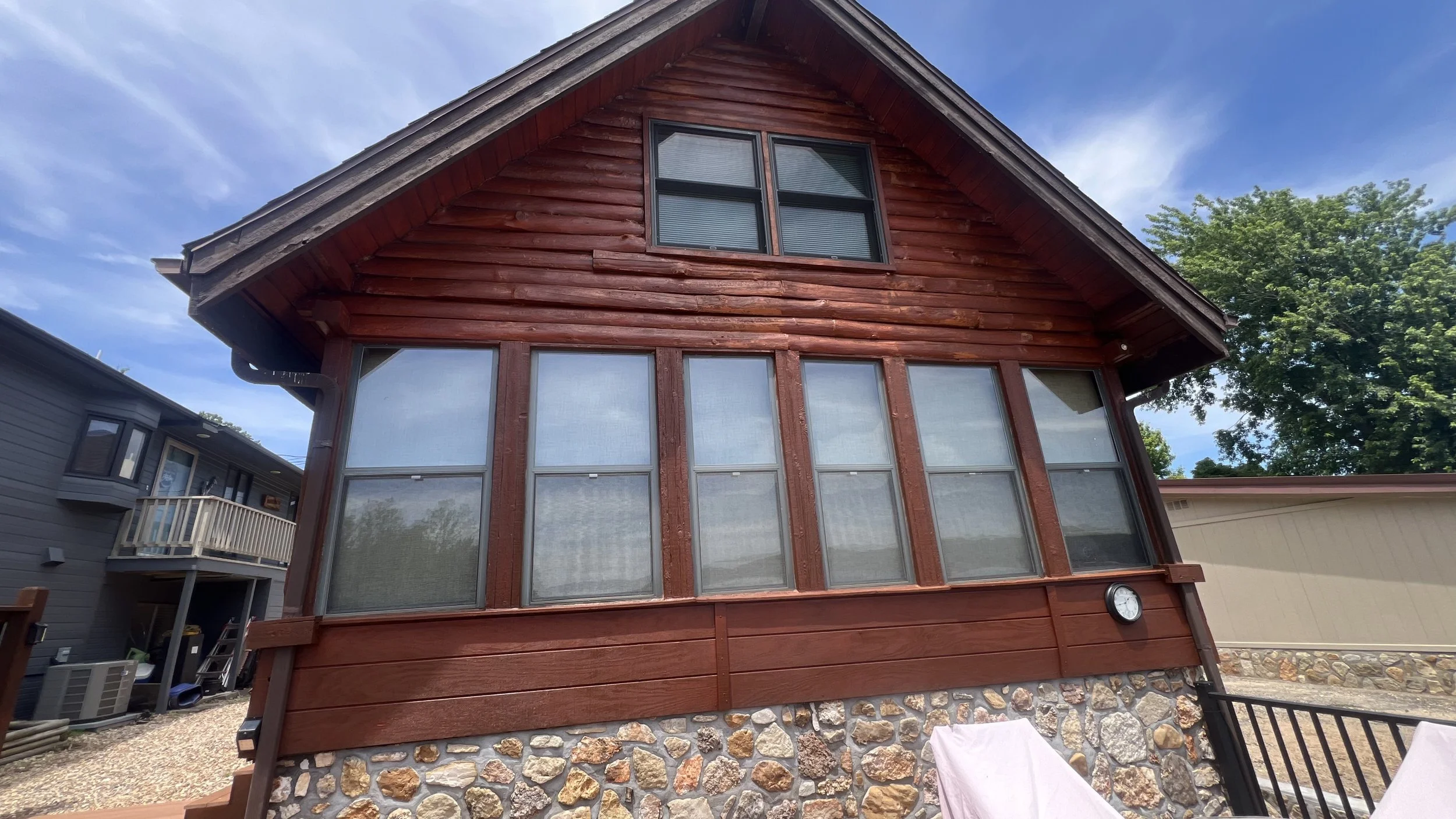 Close-up of corner notched logs showing uniform stain coverage by Quality Control Painting on an Eldon log home.