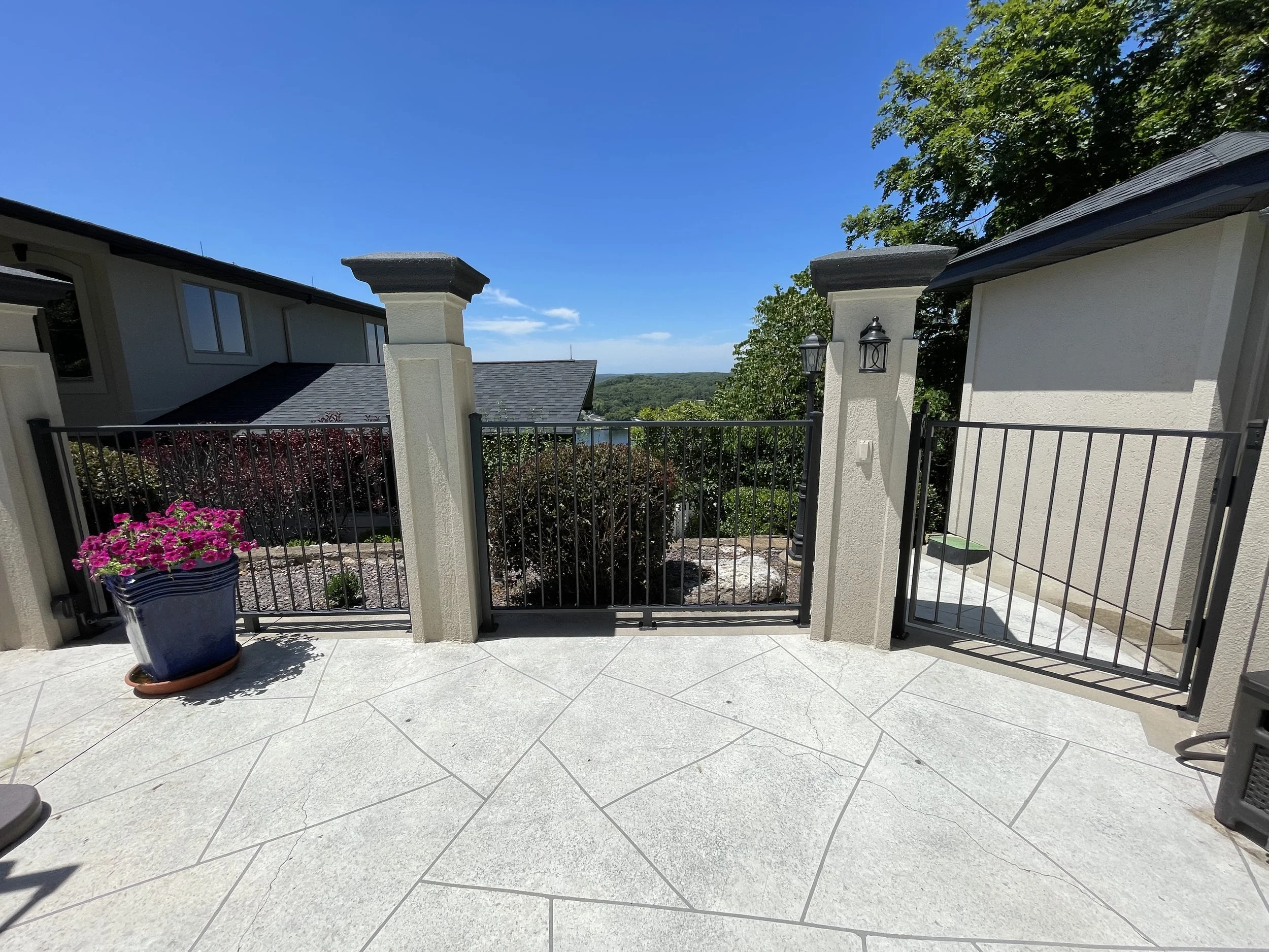 High-contrast black metal gate and perimeter fence restoration by Quality Control Painting at a private Osage Beach residence.