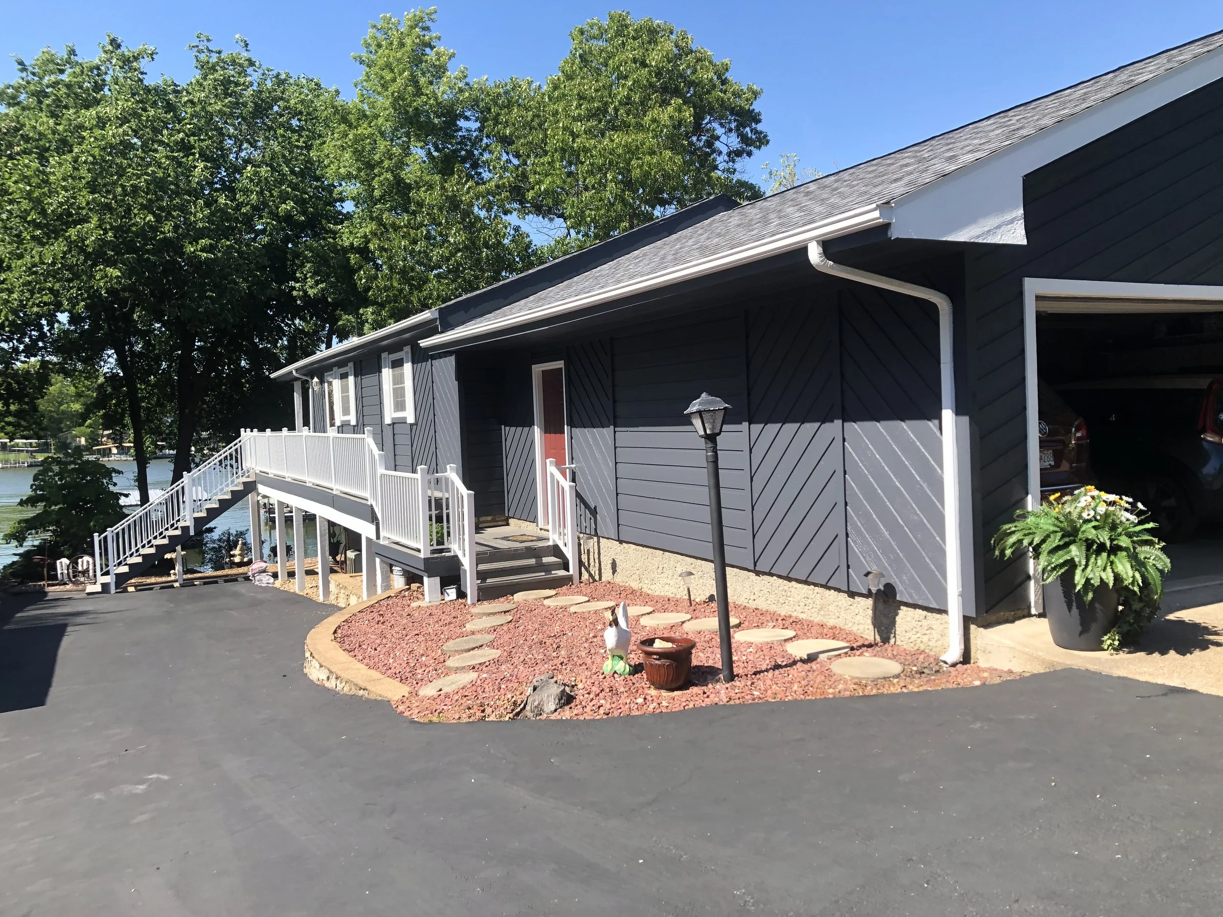 Navy blue siding and white overhead door painting on a detached garage by Quality Control Painting in Lake Ozark.
