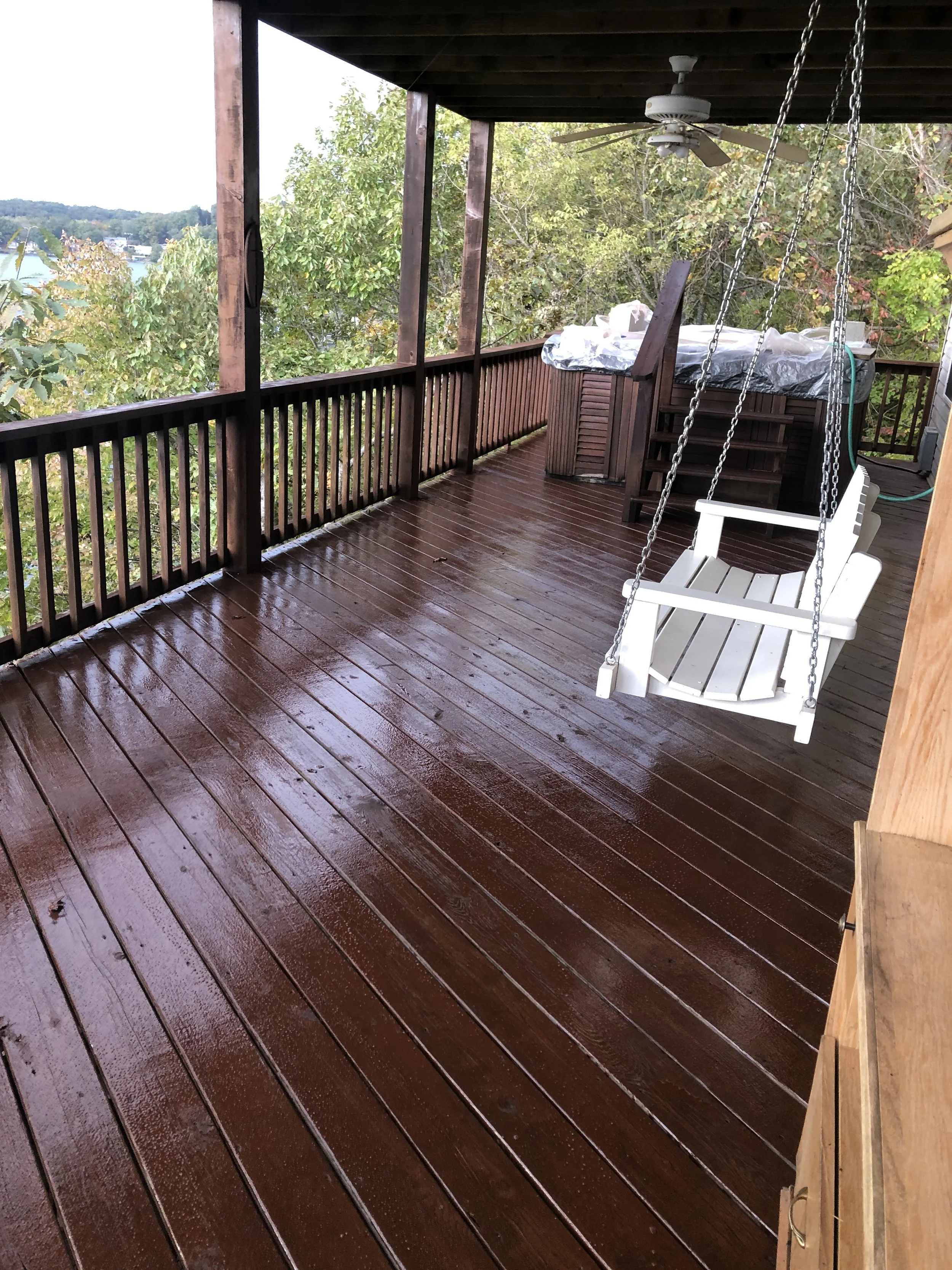 Custom painted porch swing integrated into a massive multi-level deck by Quality Control Painting in Lake Ozark.