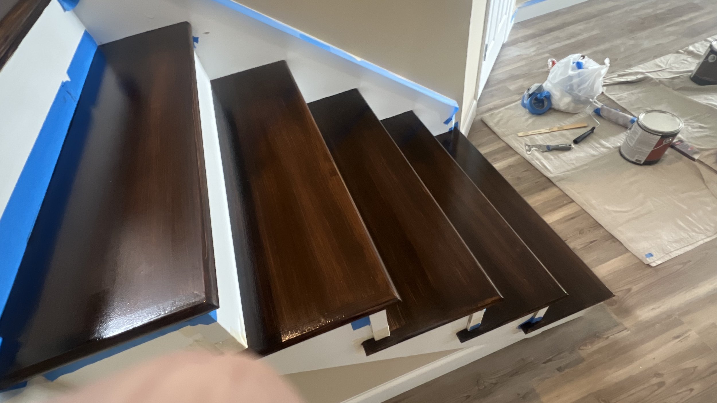 Interior staircase restoration in Laurie with white painted spindles and stained wood treads by Quality Control Painting.