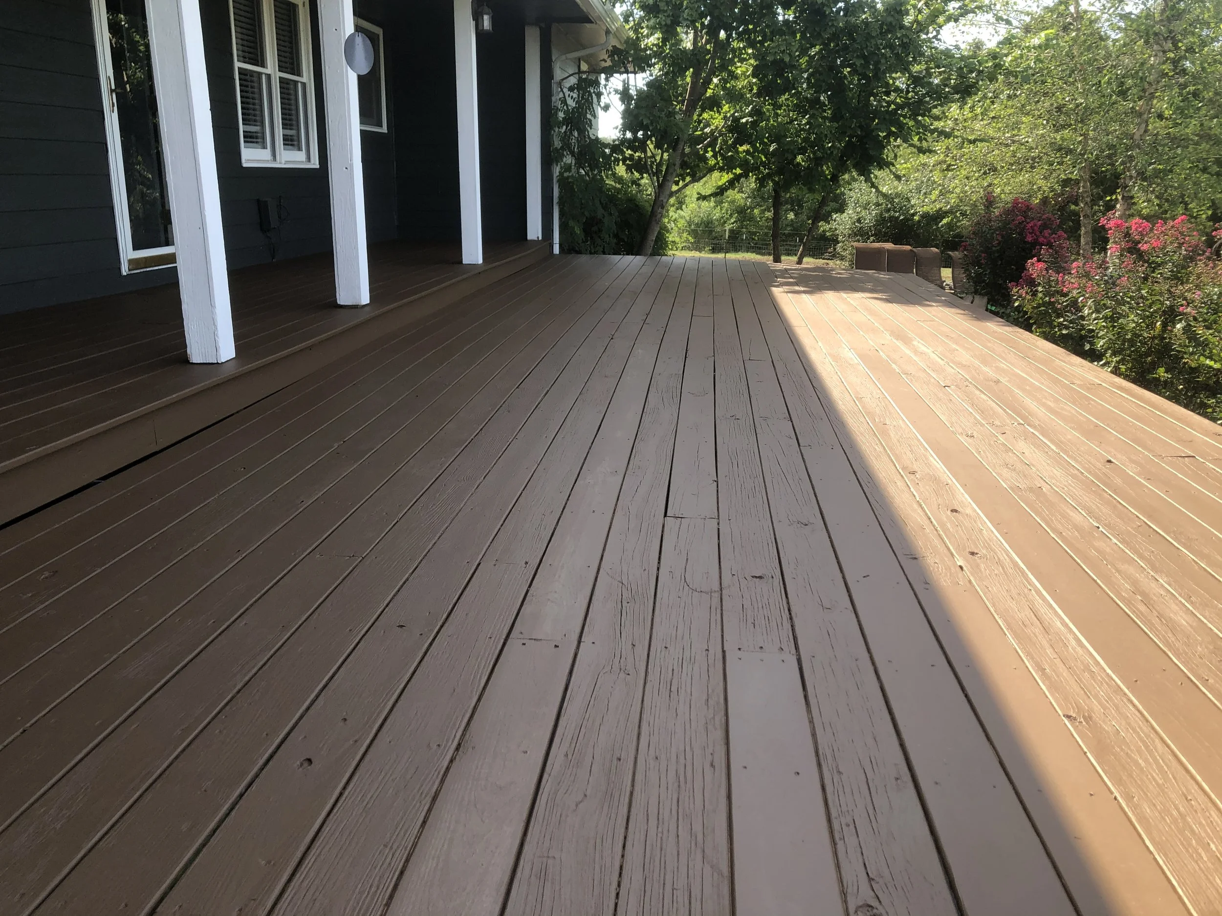 Painted heavy timber deck pillars and underside framing by Quality Control Painting at a Camdenton residence.