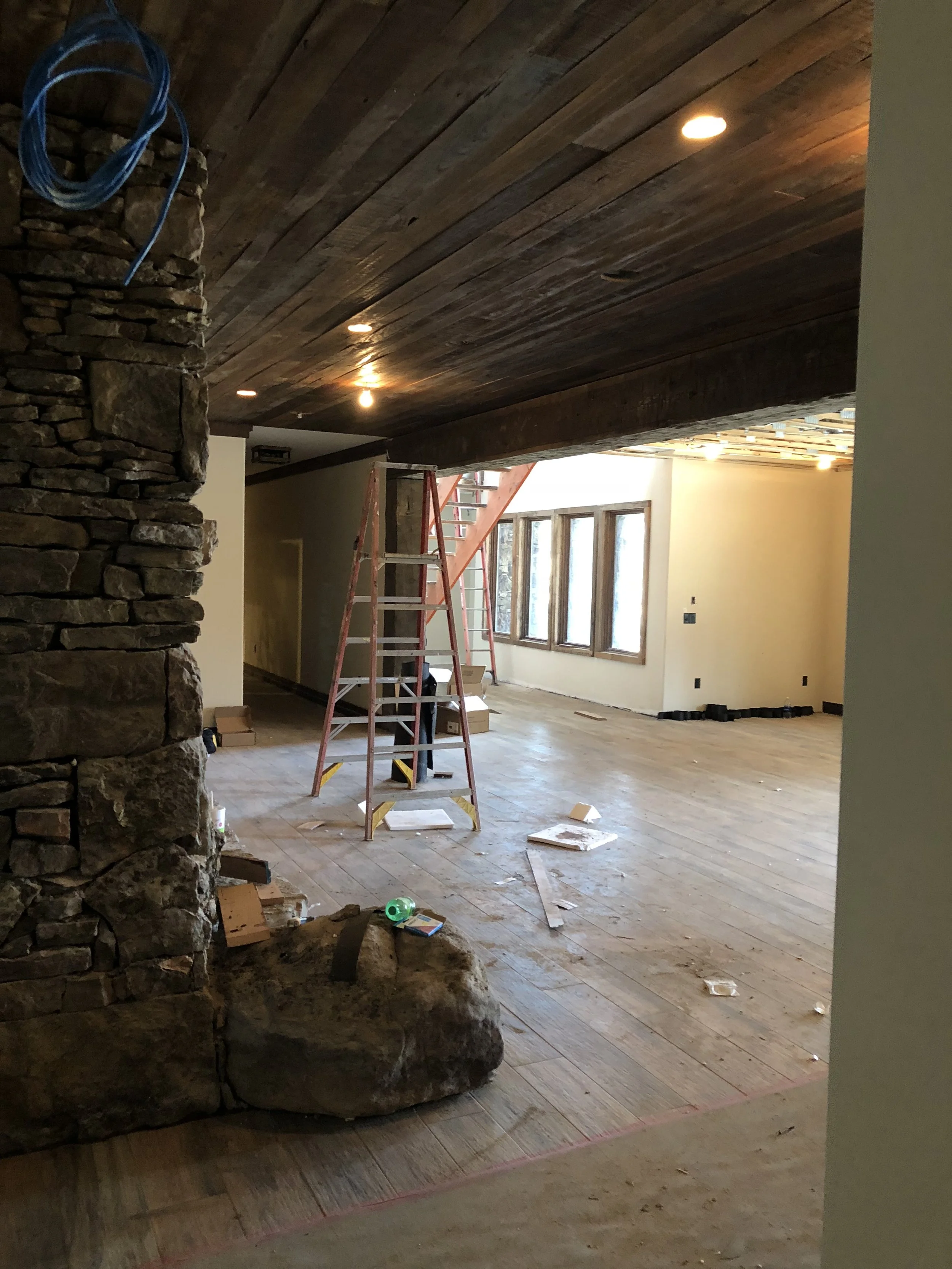 Quality Control Painting performing interior paint prep for a luxury new build in Osage Beach featuring stone and wood accents.
