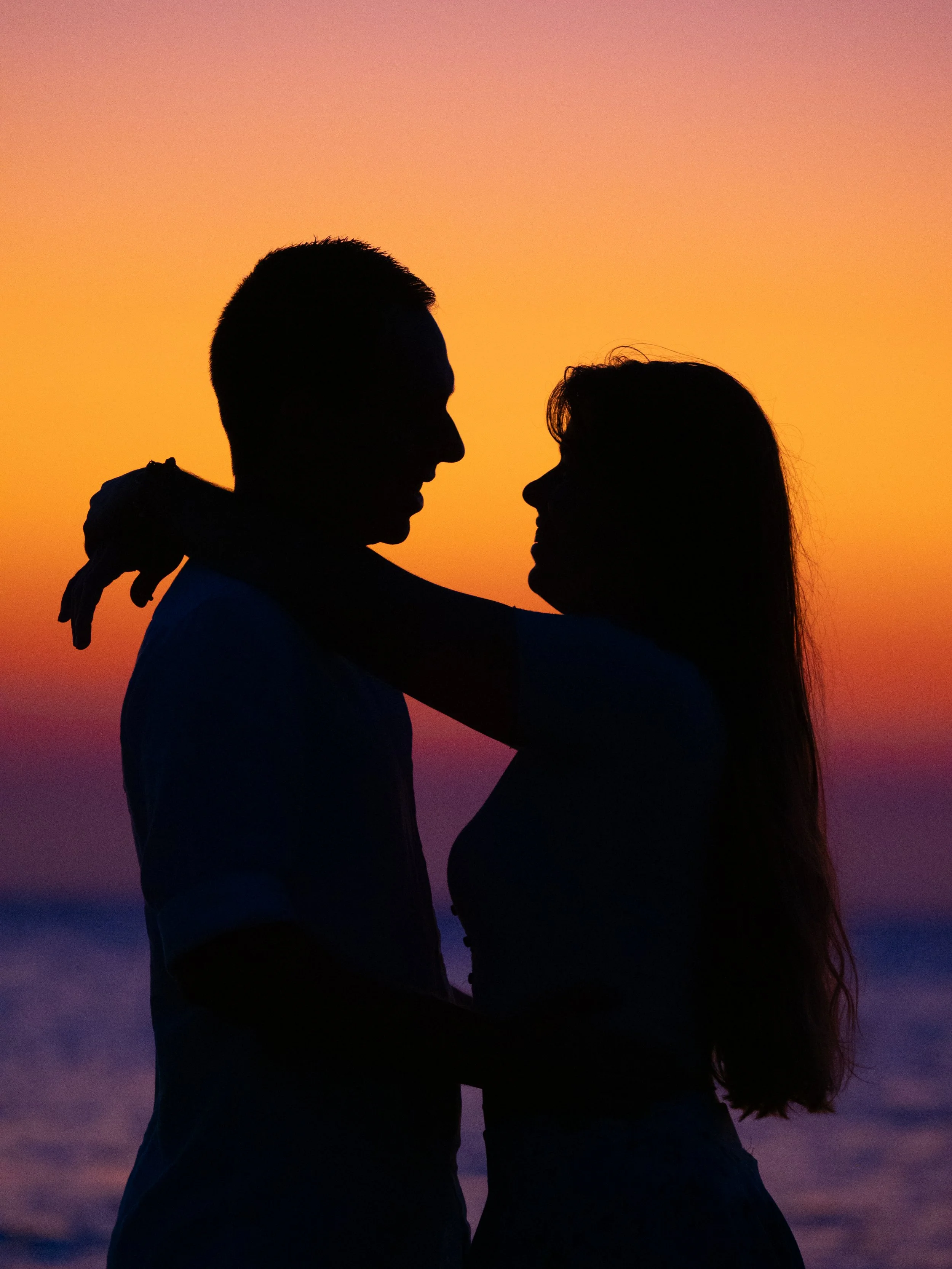 Silhouette of a couple hugging at sunrise