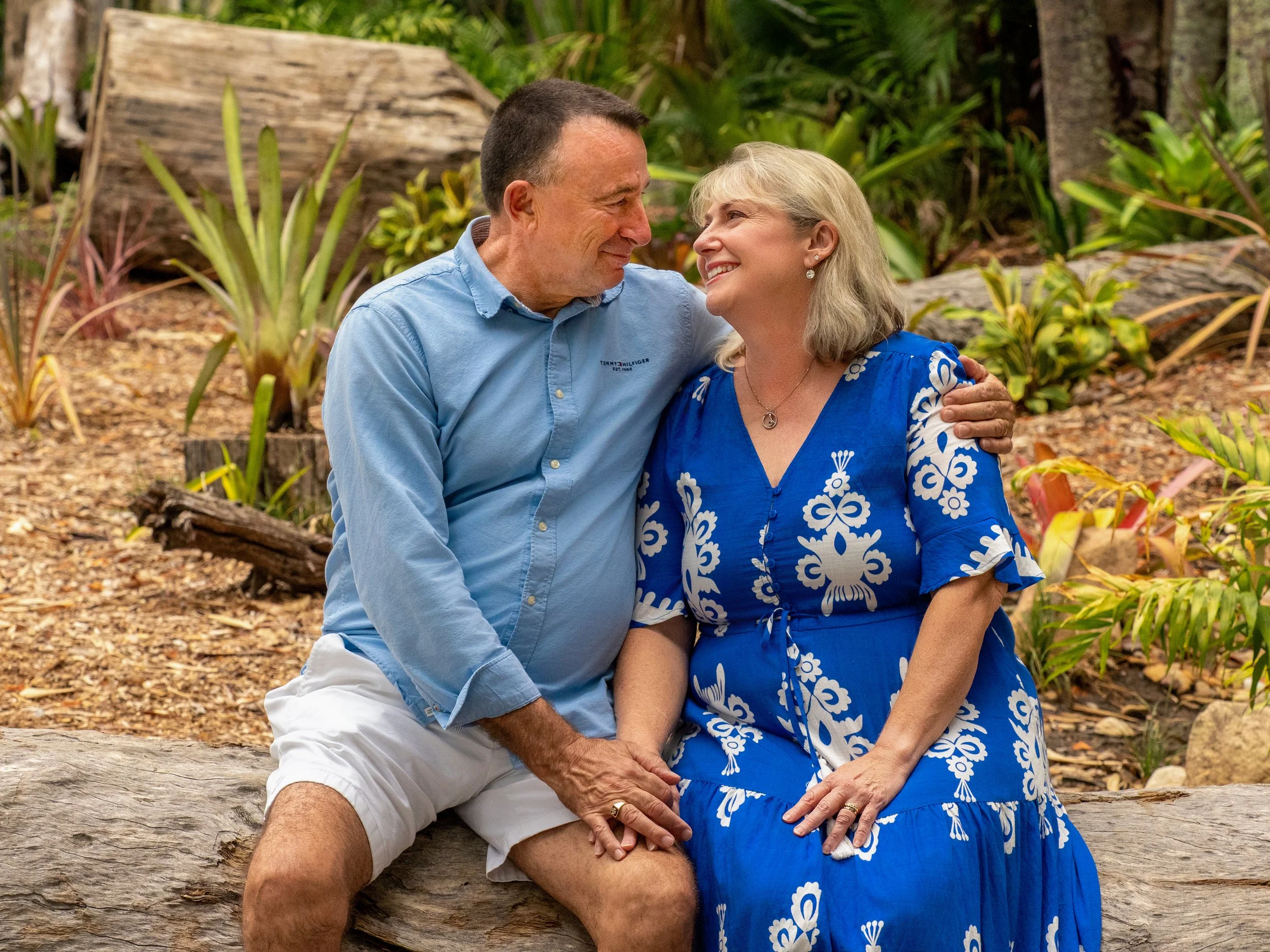 Intimate couple sitting on a log fro a photo