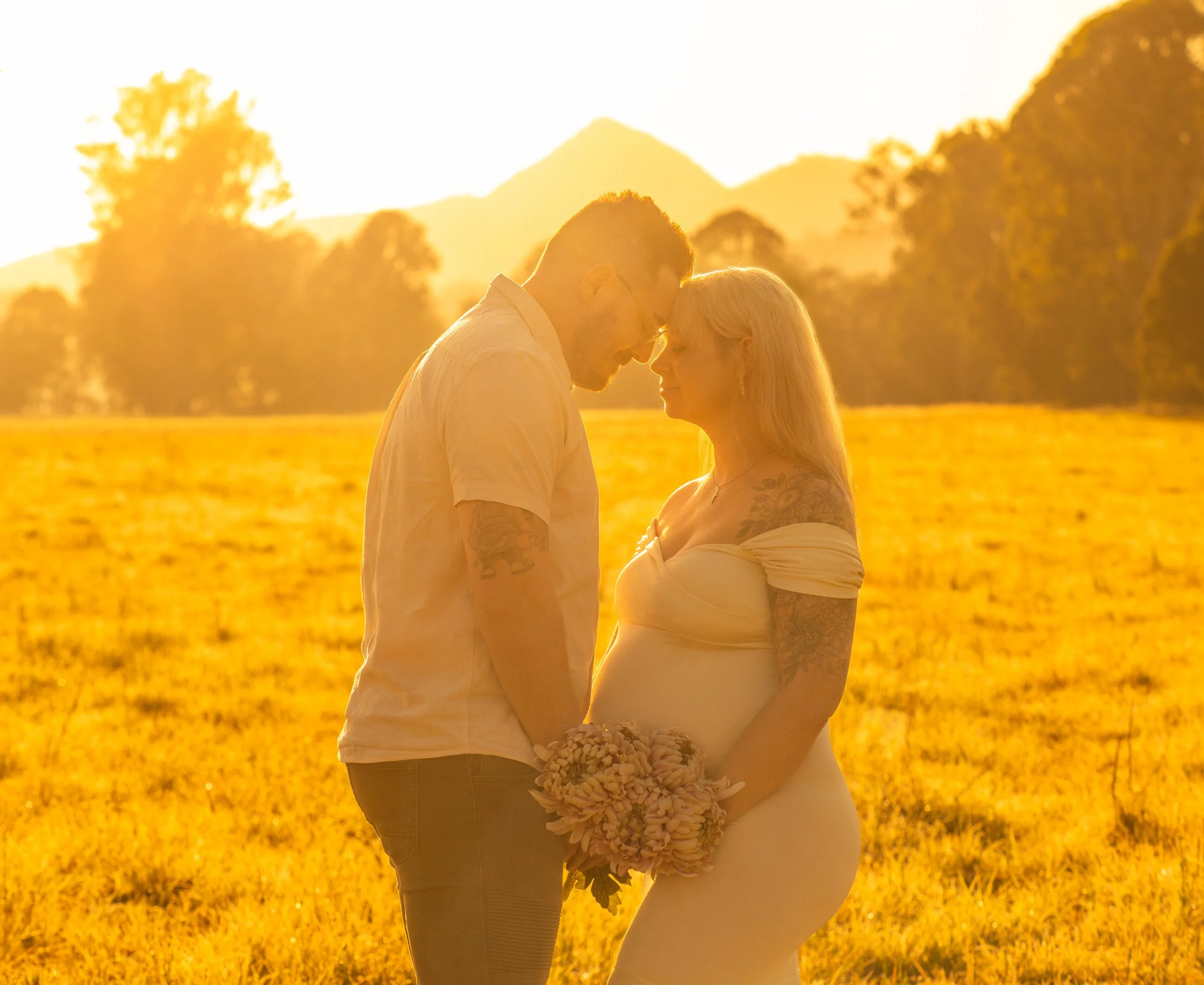 A couple standing intimately close soaking in the celebration of their coming baby in a maternity session in the Scenic Rim.