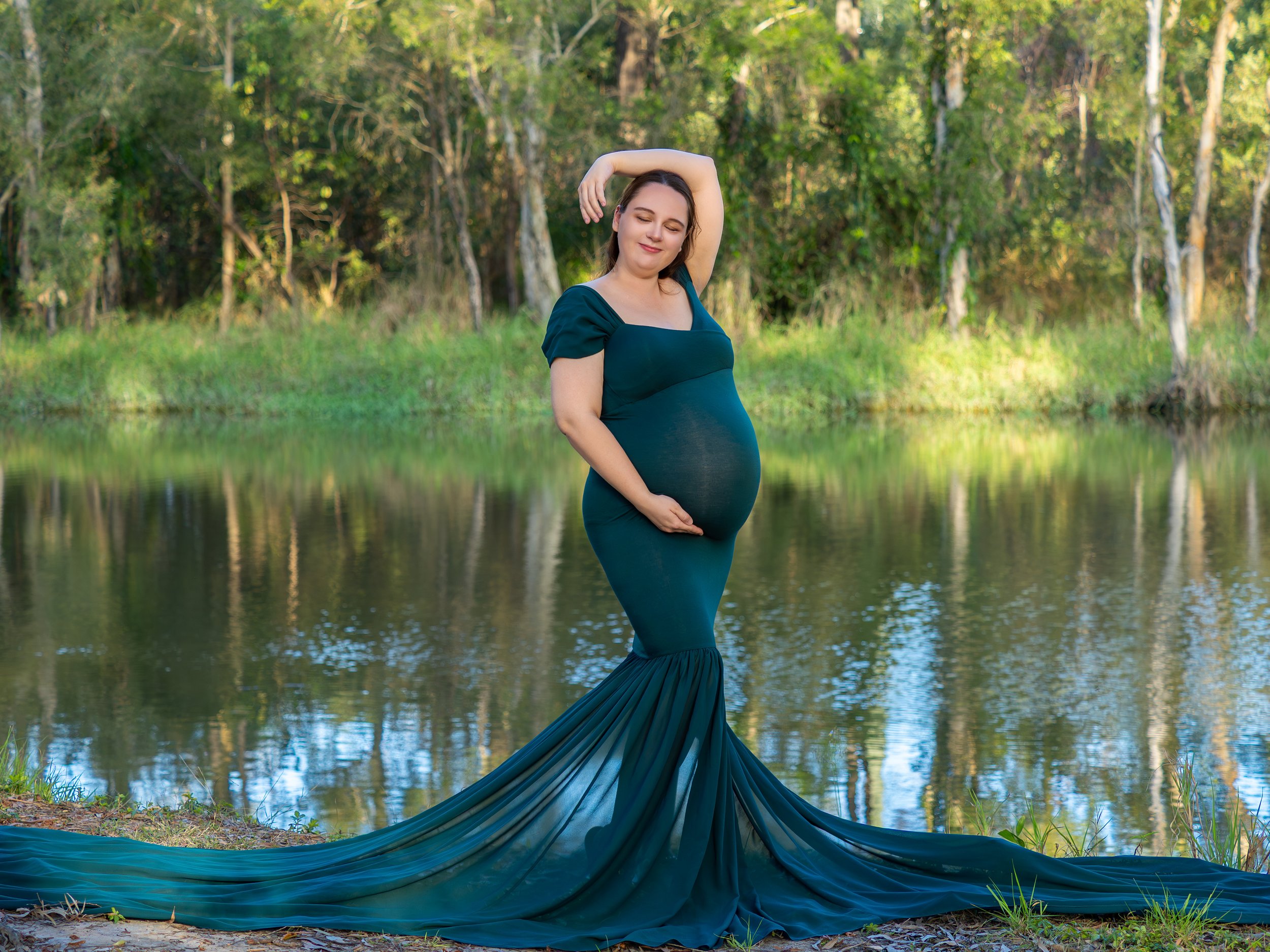 Pregnant mother basking in the glow of preganancy near a Logan river.