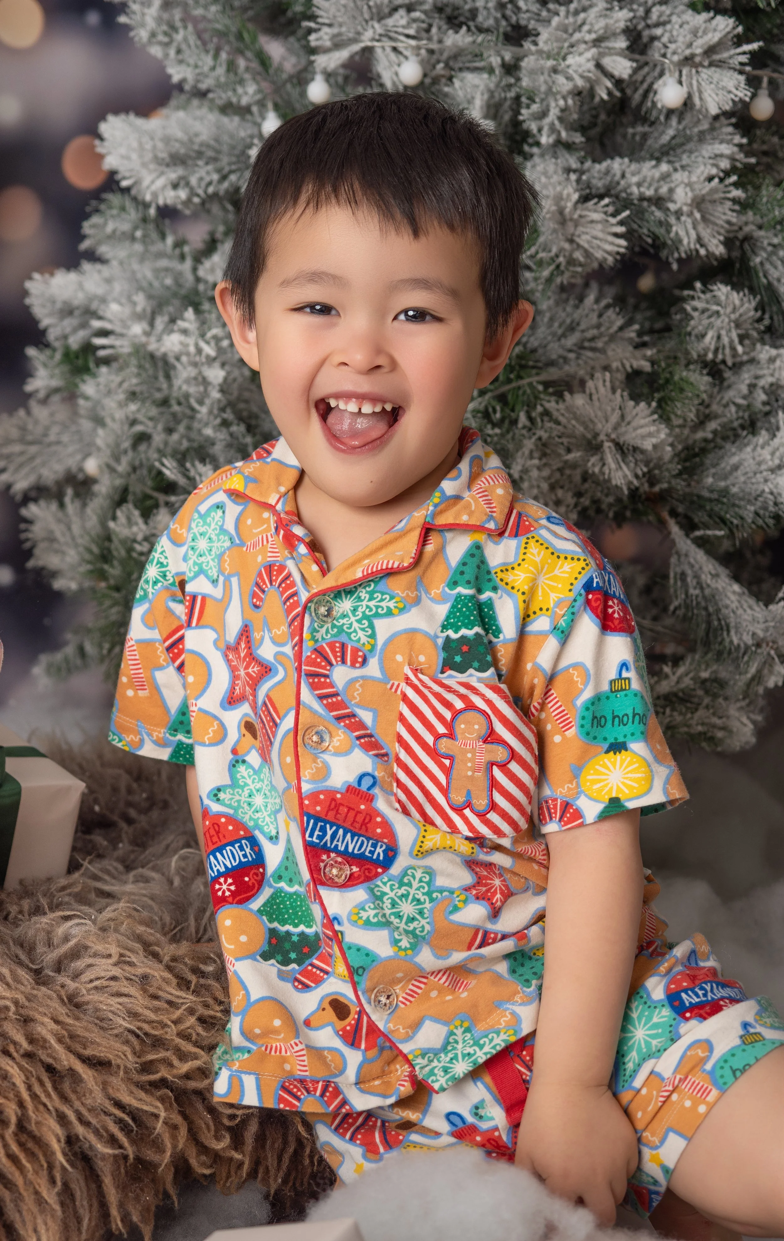 Cheeky Asian little boy smiling during the snowy Winter Wonderland Christmas mini session in Ipswich