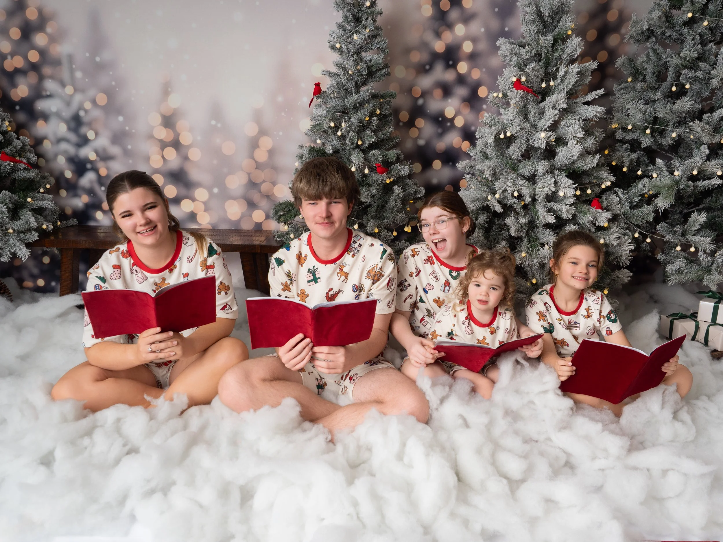 Family of five wearing coordinating Christmas pyjamas during a fun singing Christmas carrols Christmas mini session