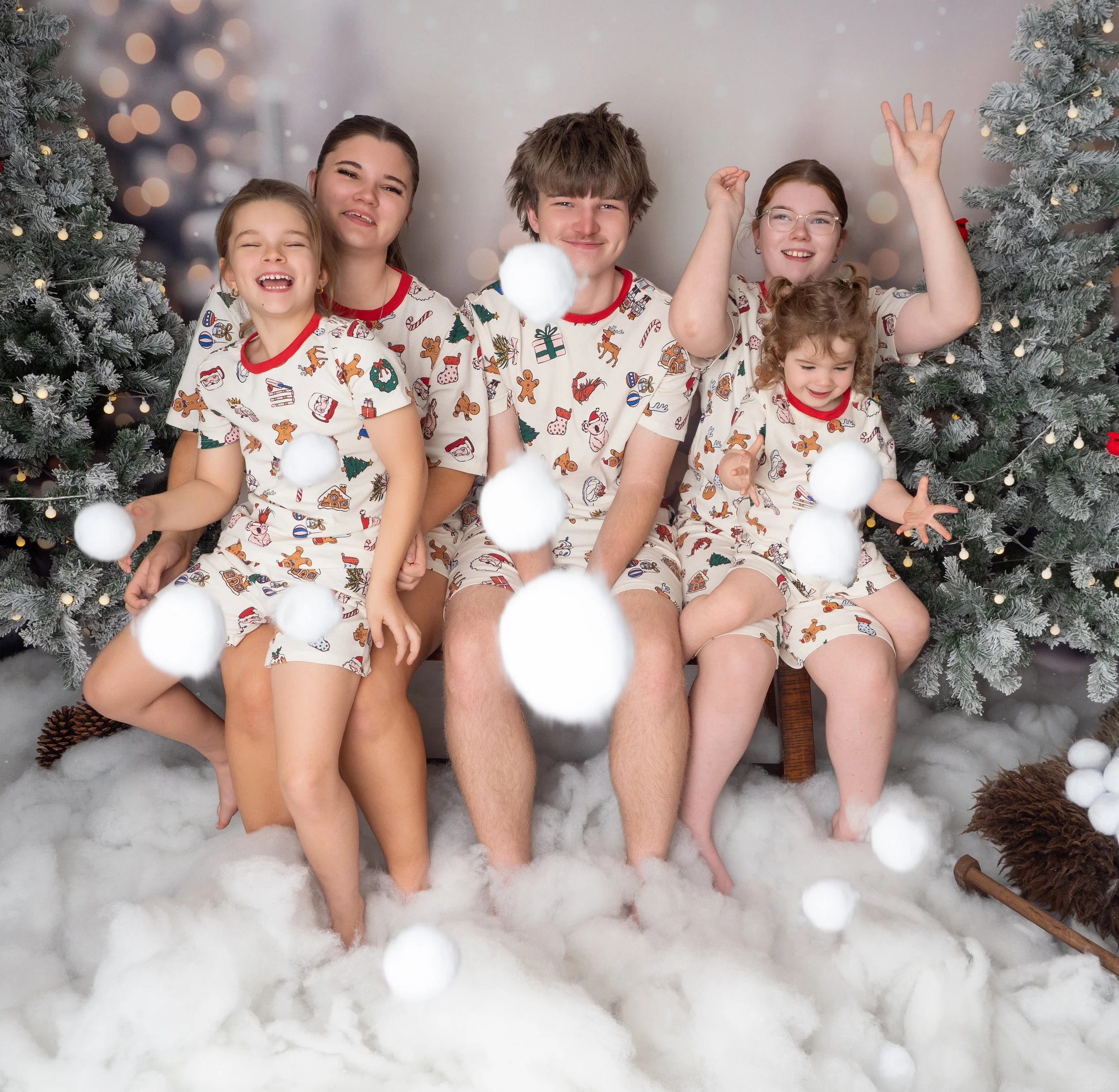 Five siblings throwing snowballs during a Winter Wonderland Christmas mini session in Ipswich