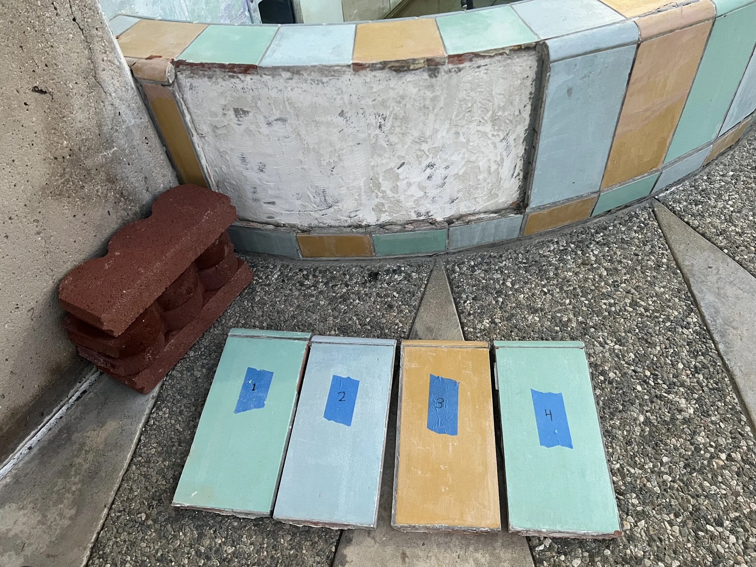 Tiles are being set with thin set mortar along the basin of the art fountain.