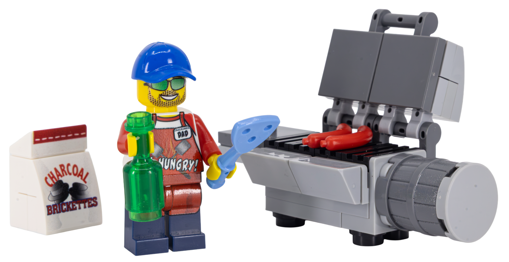 LEGO minifigure with a blue cap, sunglasses, yellow beard, and red apron grilling hot dogs on a LEGO barbecue. The minifigure is holding a green bottle and a spatula. There is a white box of charcoal briquettes nearby.