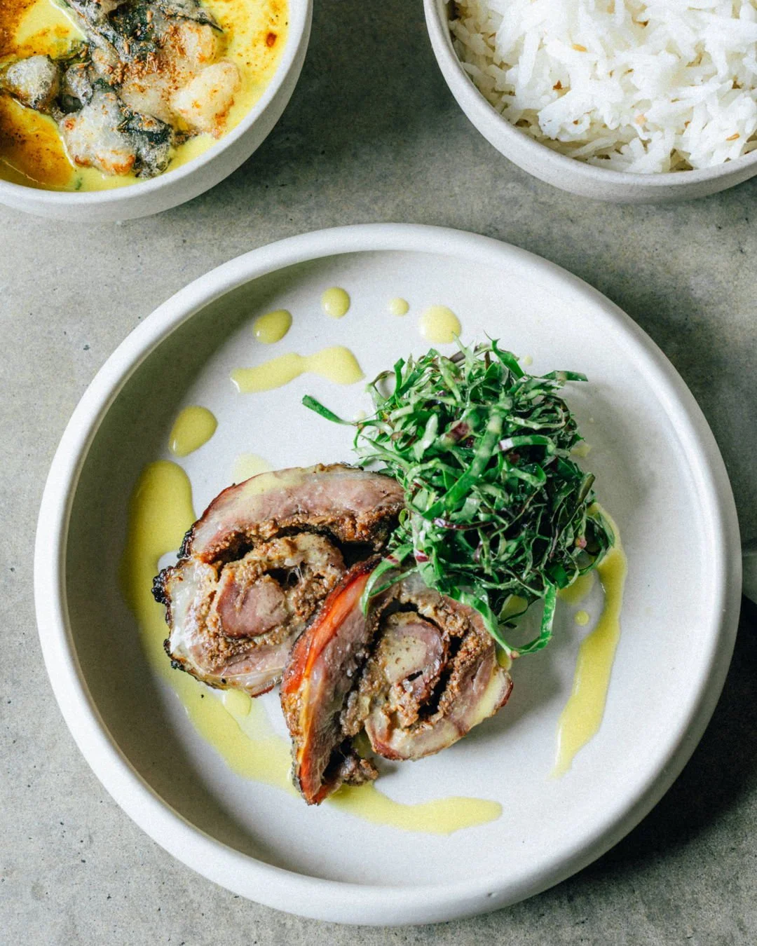 Lamb brisket from @loddonvalleylamb is rolled and marinated in traditional kebab spices, then grilled over wood for a charred finish. The kebab is paired with bitter greens from @dogcreek.growers for balanced flavours, then topped with a drizzle of q