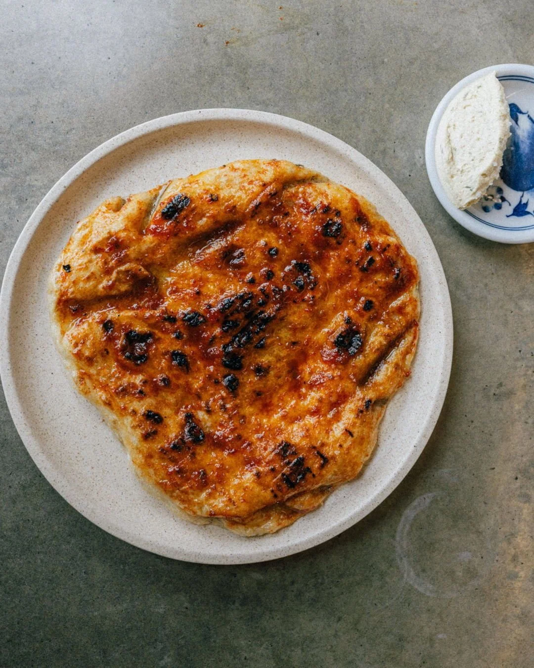 Flatbread supremacy &mdash; grilled whole wheat dough, preserved chilli, roasted garlic butter. Excellent with toppings, unstoppable without them.