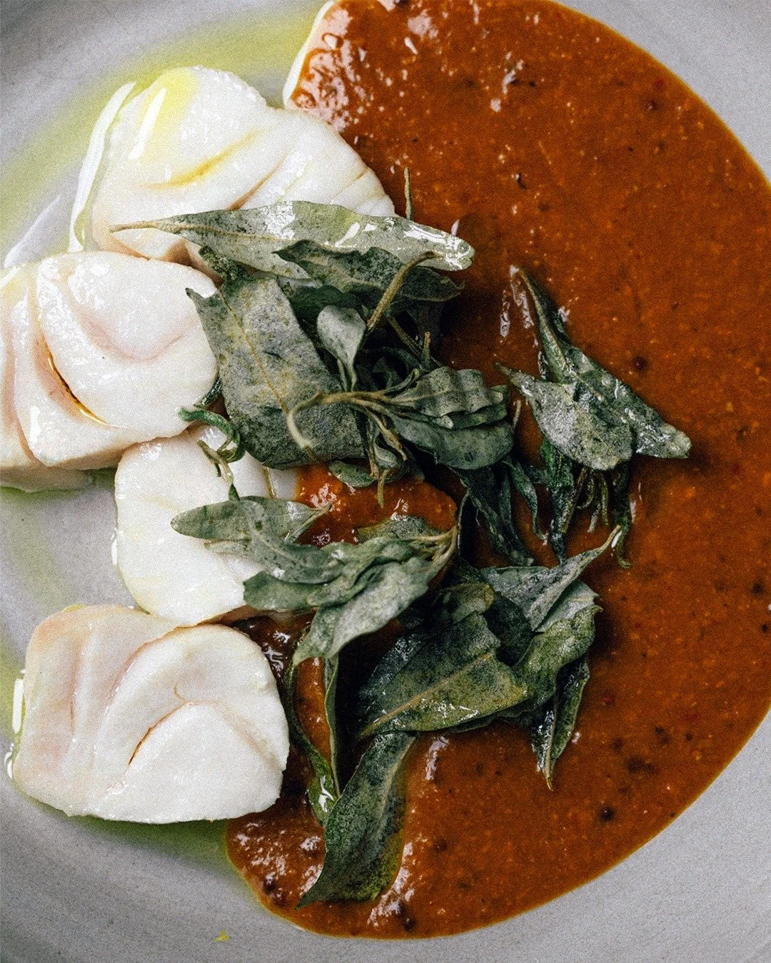 Hapuka Manga Kuzhambu &mdash; Hapuka, mango and tamarind curry, saltbush.

Kuzhambu is South Indian staple, characterised by its tamarind base infused with a subtle mixture of spices and coconut.

We use delicious Kensington pride mangos for our kuzh