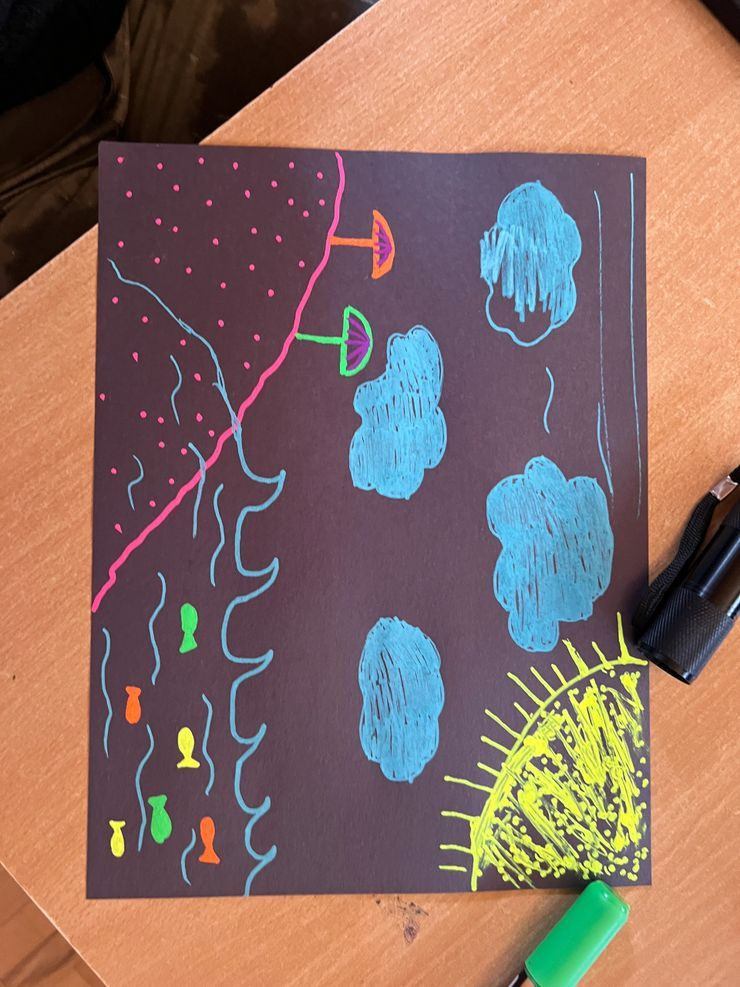Colorful drawing of a nature scene featuring a sunset with yellow rays, blue clouds, pink and green trees, and colorful fish swimming in water, all on a black background.