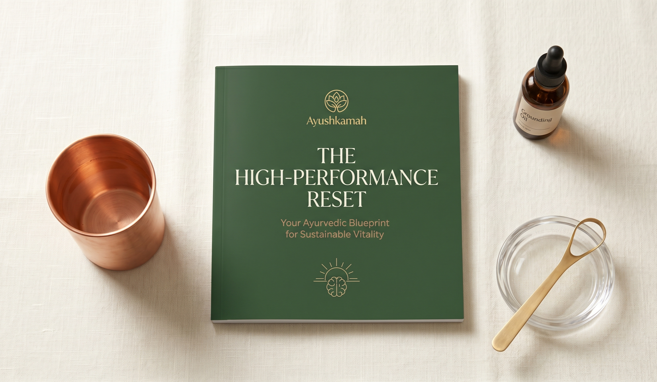 A green book titled 'The High-Performance Reset' by Ayushkamah, a copper cup, a small amber bottle labeled 'Grounding Oil' with a dropper, a clear glass bowl, and a gold-colored stirring tool on a white surface.