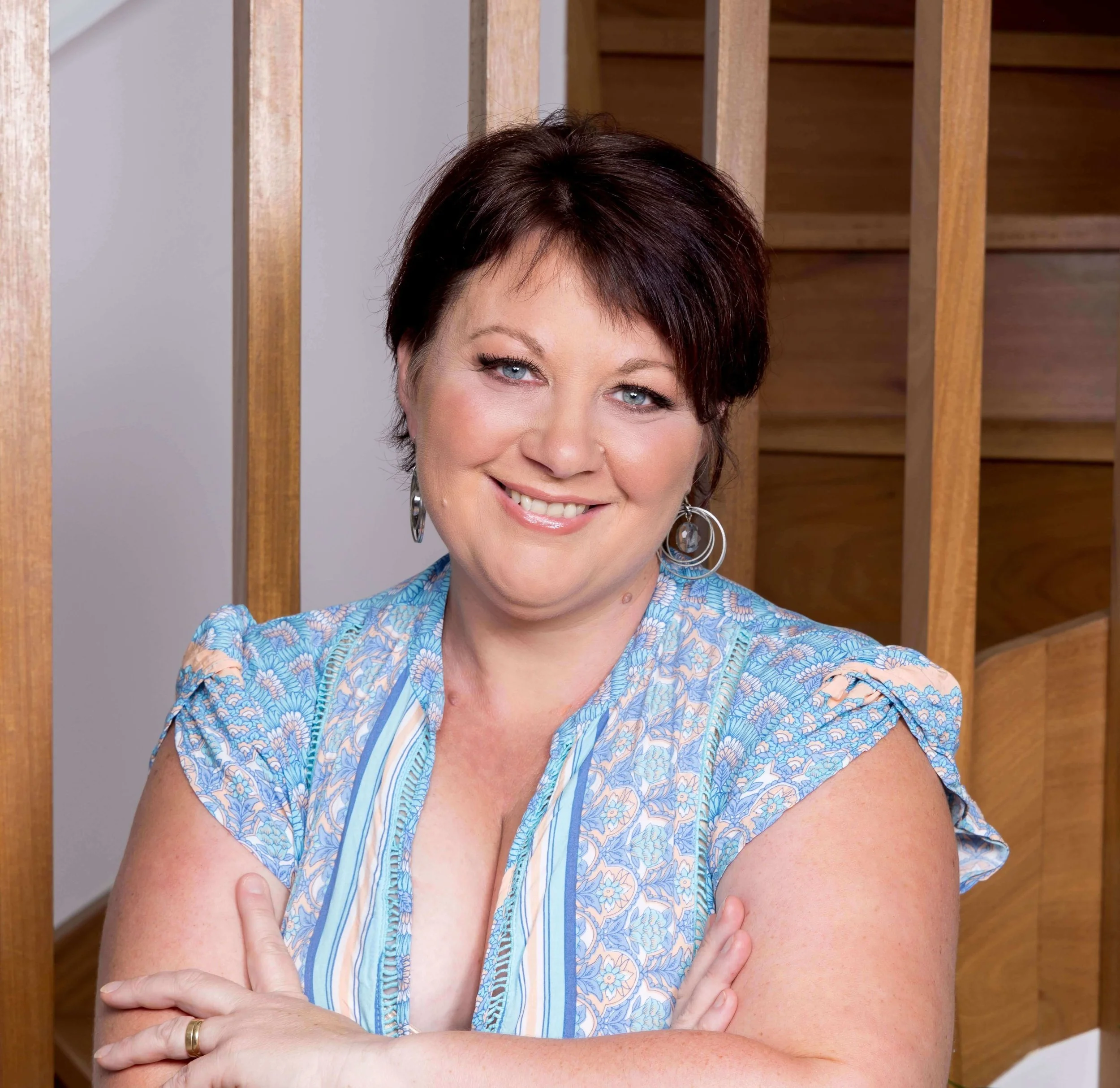 Philippa Scott smiling with short dark hair and blue eyes posing indoors against wooden paneling.