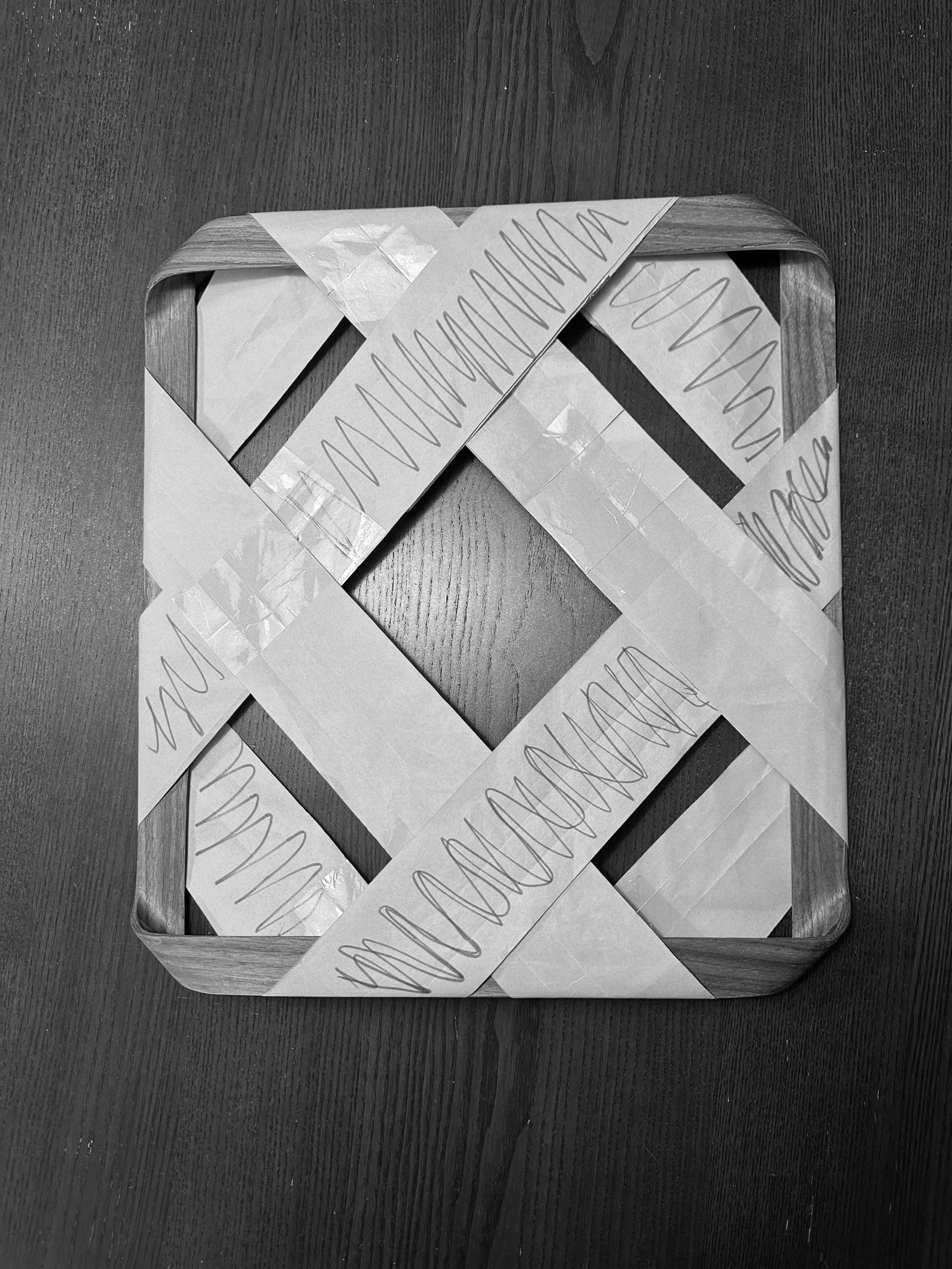 A wooden tray containing folded paper strips with handwritten