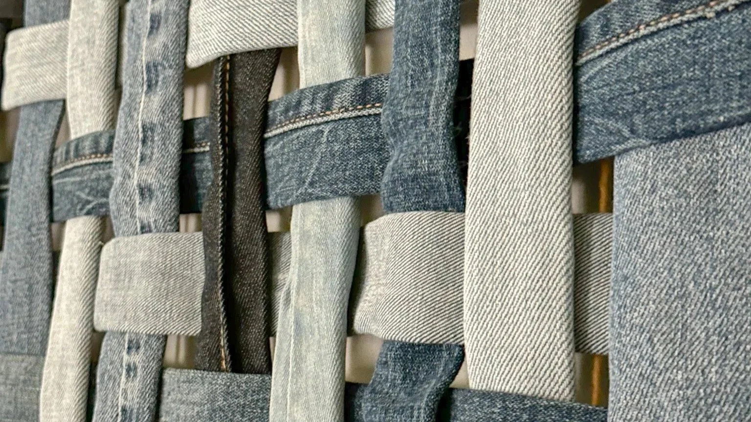 Close-up of Wall art piece made of woven reclaimed denim fabric strips framed in oak wood, featuring various shades of denim | Ana Salazar Atelier