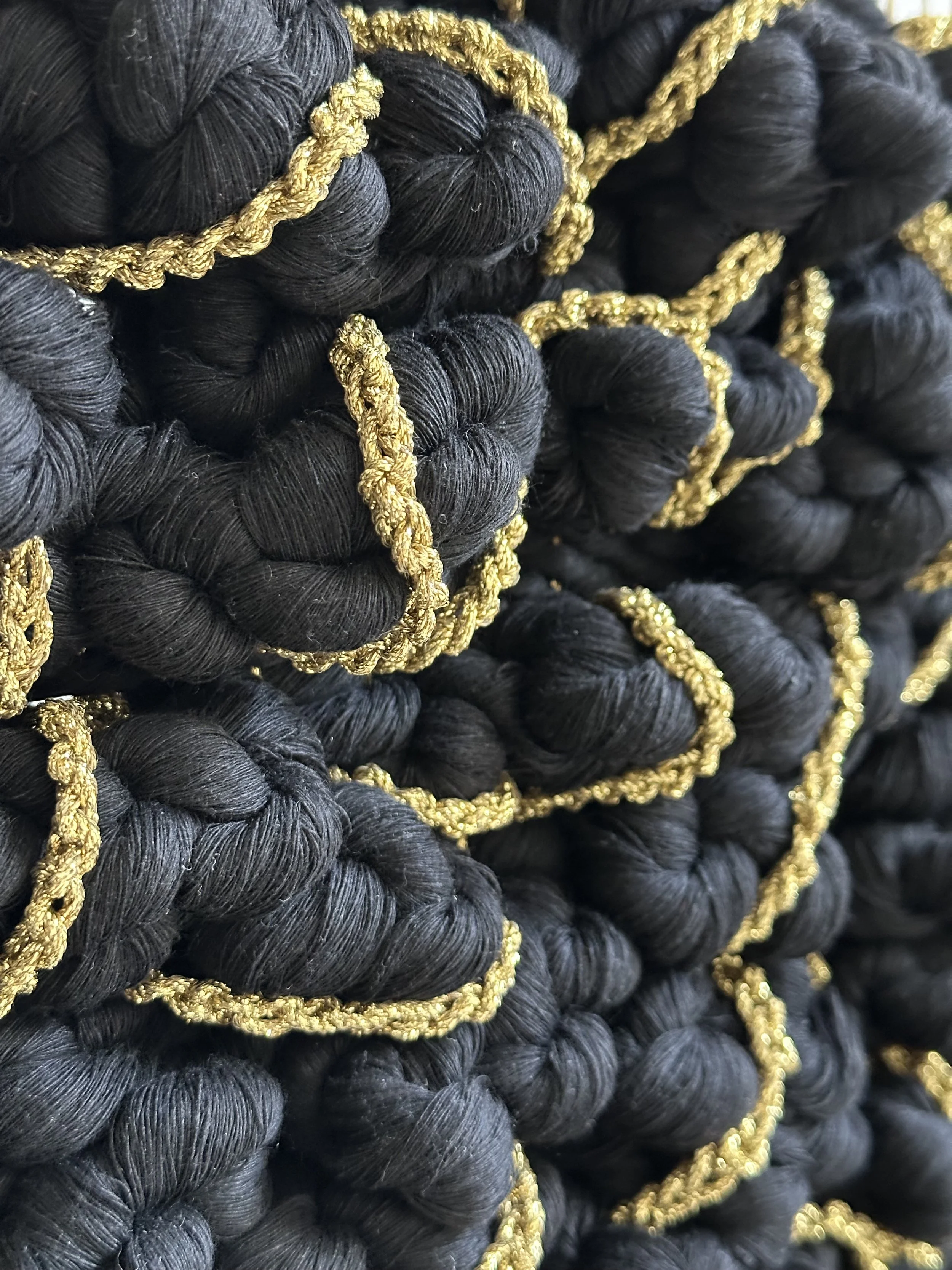 Close-up of Gilded Peaks by Ana Salazar – Detailed view of intricate hand-knotted section in golden and black fibers.