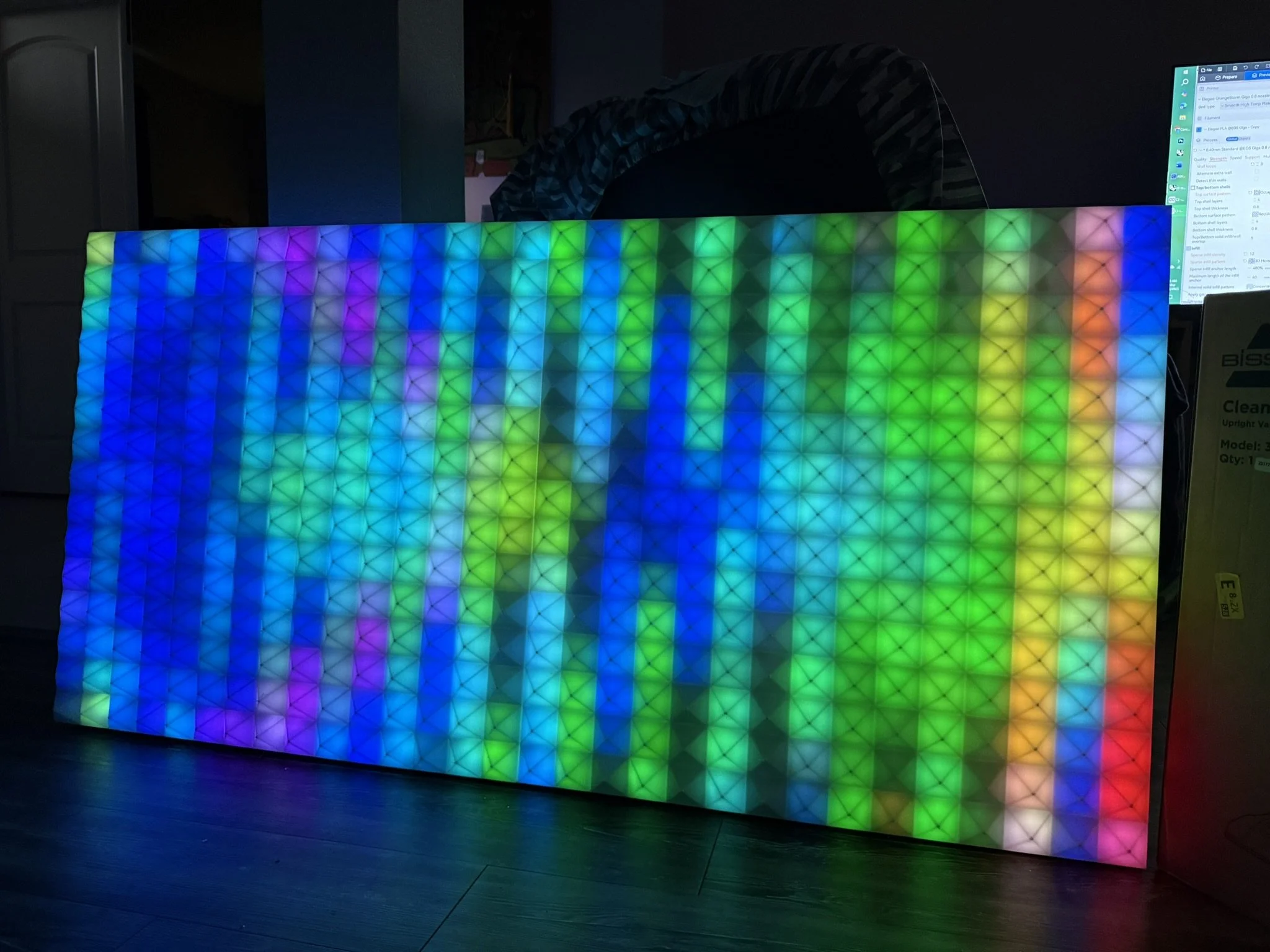 Colorful LED light display with a geometric pattern of illuminated triangular sections.