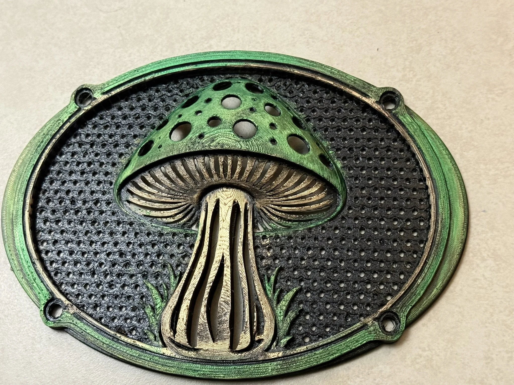 Close-up of a cut section of a green and black metallic mechanical object with intricate design and circular holes.