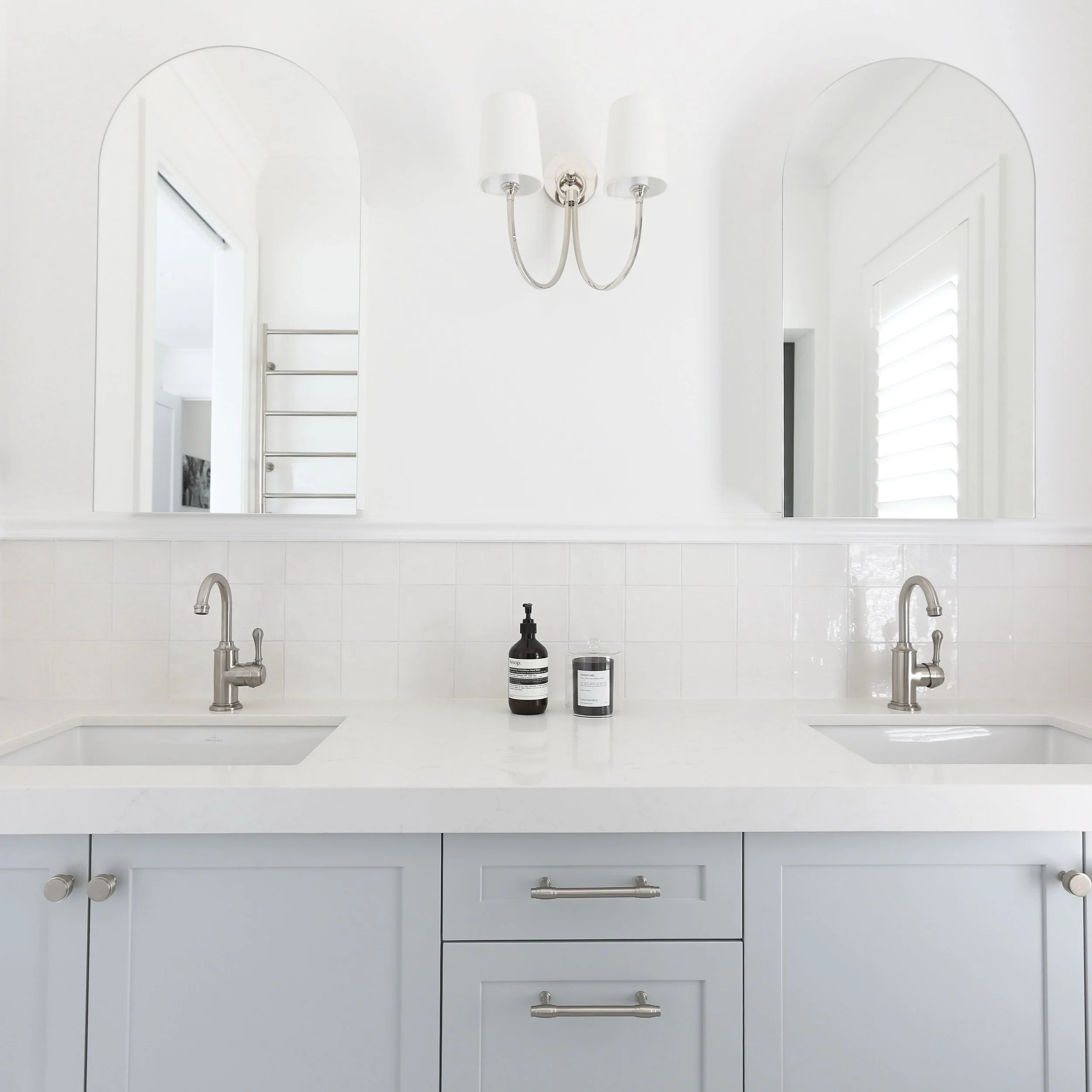 Soft grey joinery, brushed nickel details and a perfectly balanced double vanity. A calm, timeless bathroom with just the right amount of detail. 🤍

Designed by Artefact Interiors.

Lights @visualcomfort 
Taps @astrawalkerofficial 
Handles @hepburnh