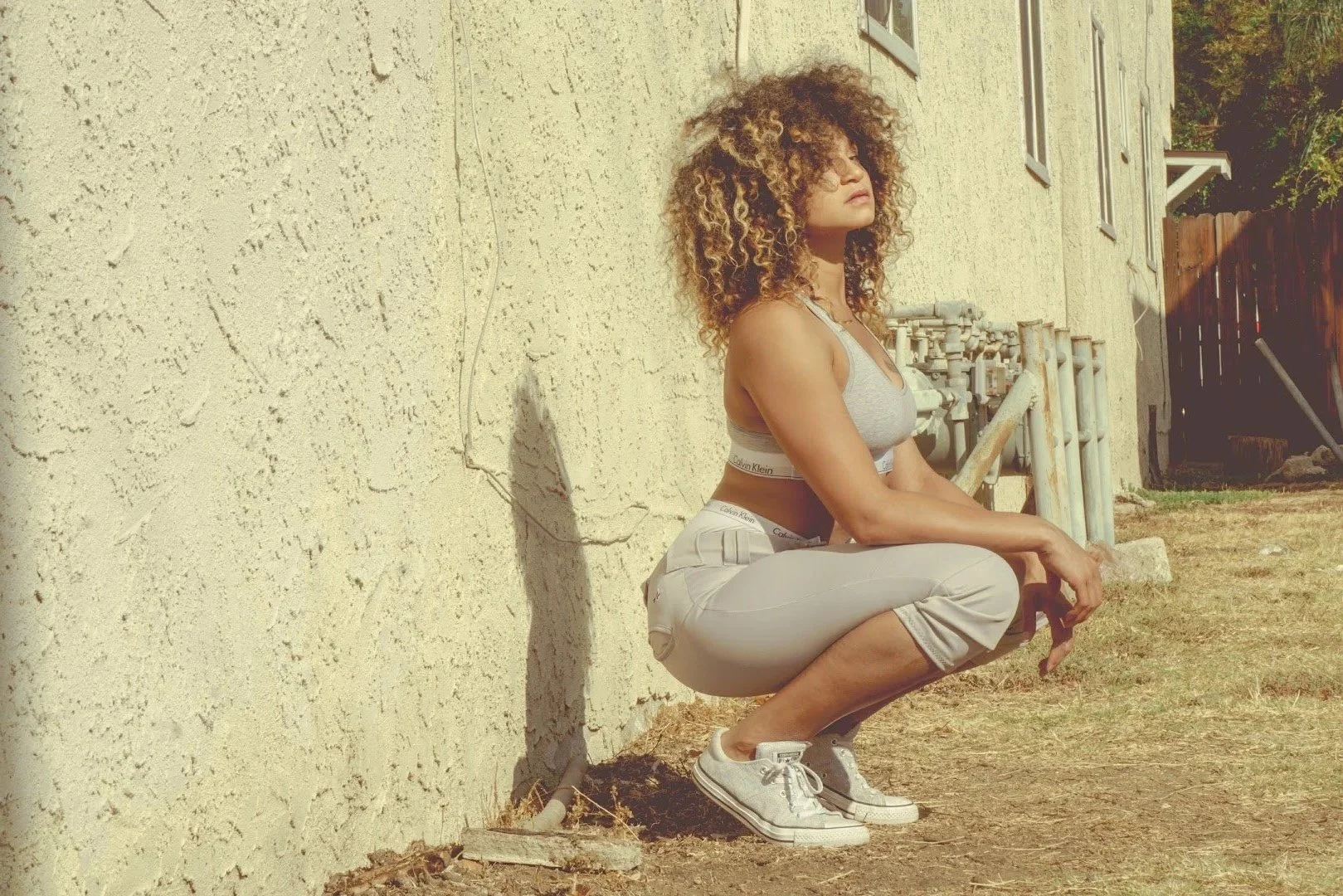 woman squatting in sand soft aesthetic photography Los Angeles