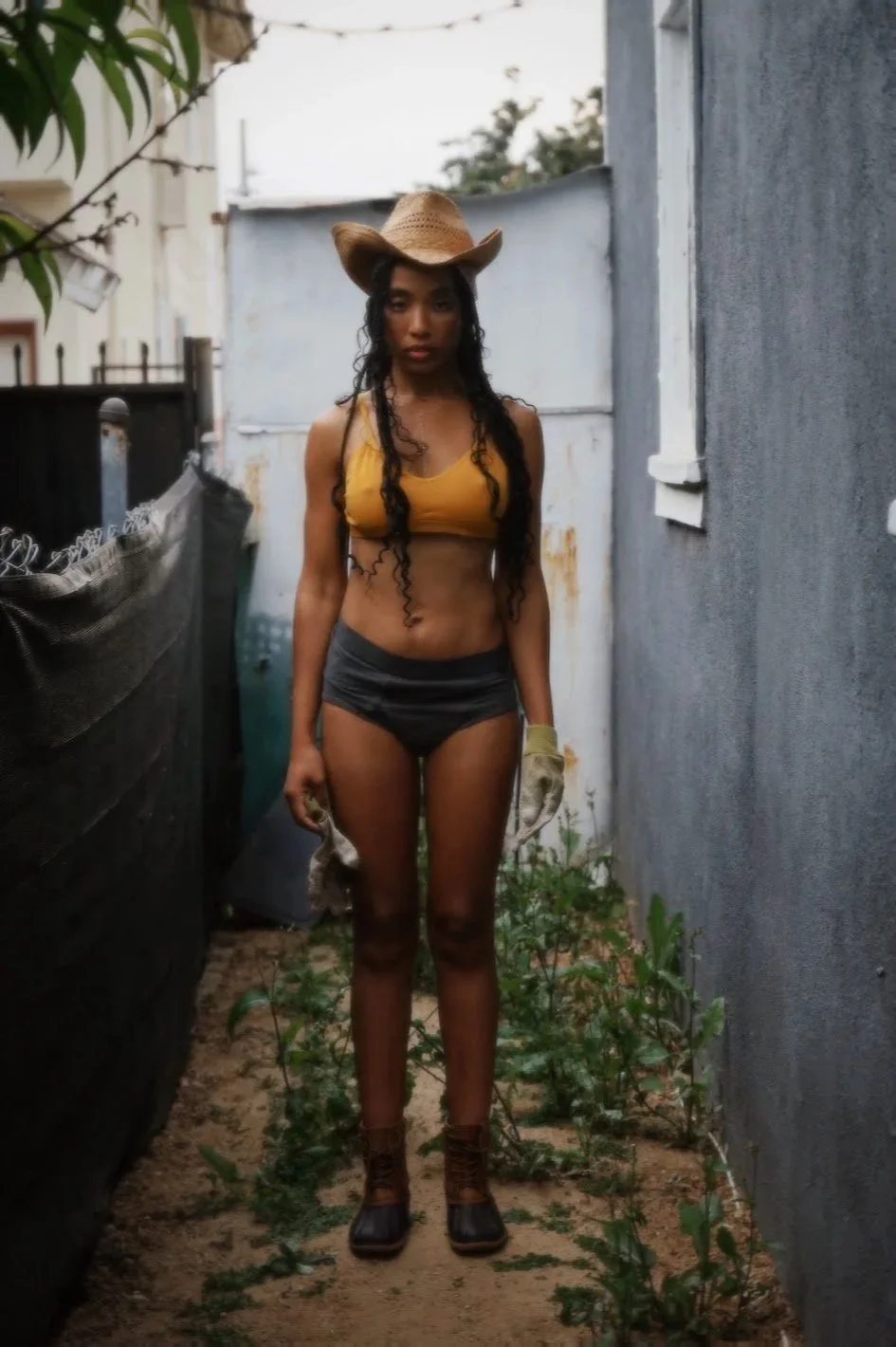 woman wearing cowboy hat standing outdoors in alley natural light lifestyle photography