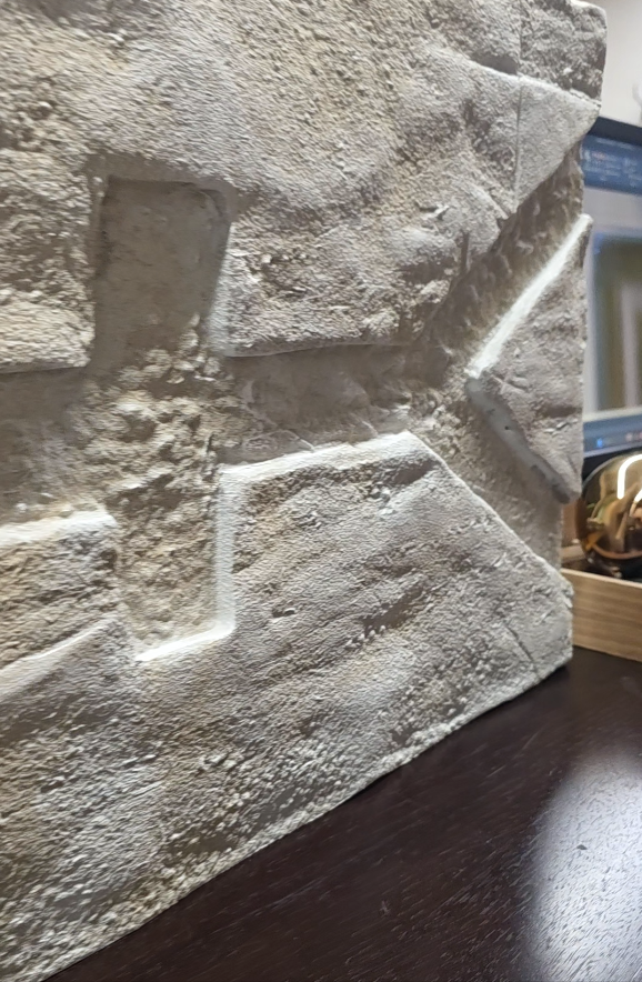 Handcrafted T-PILLAR console during production, featuring stone-like surfaces and symbolic carvings inspired by Göbeklitepe.