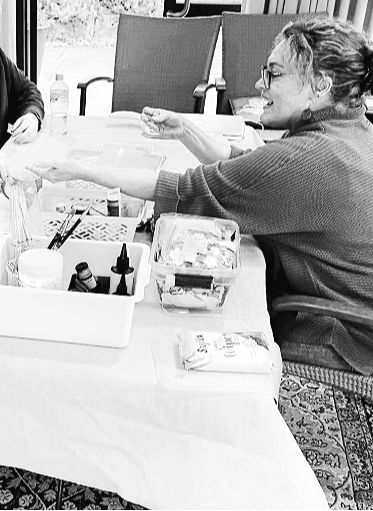 Black and white image of Michelle facilitating a community art workshop.