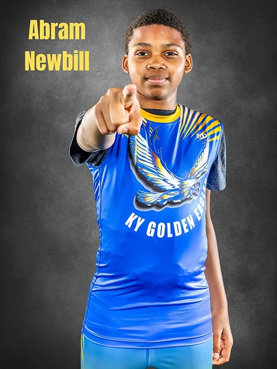 Young boy in a blue sports jersey pointing forward, with yellow text "Abram Newbill" and a gray background.