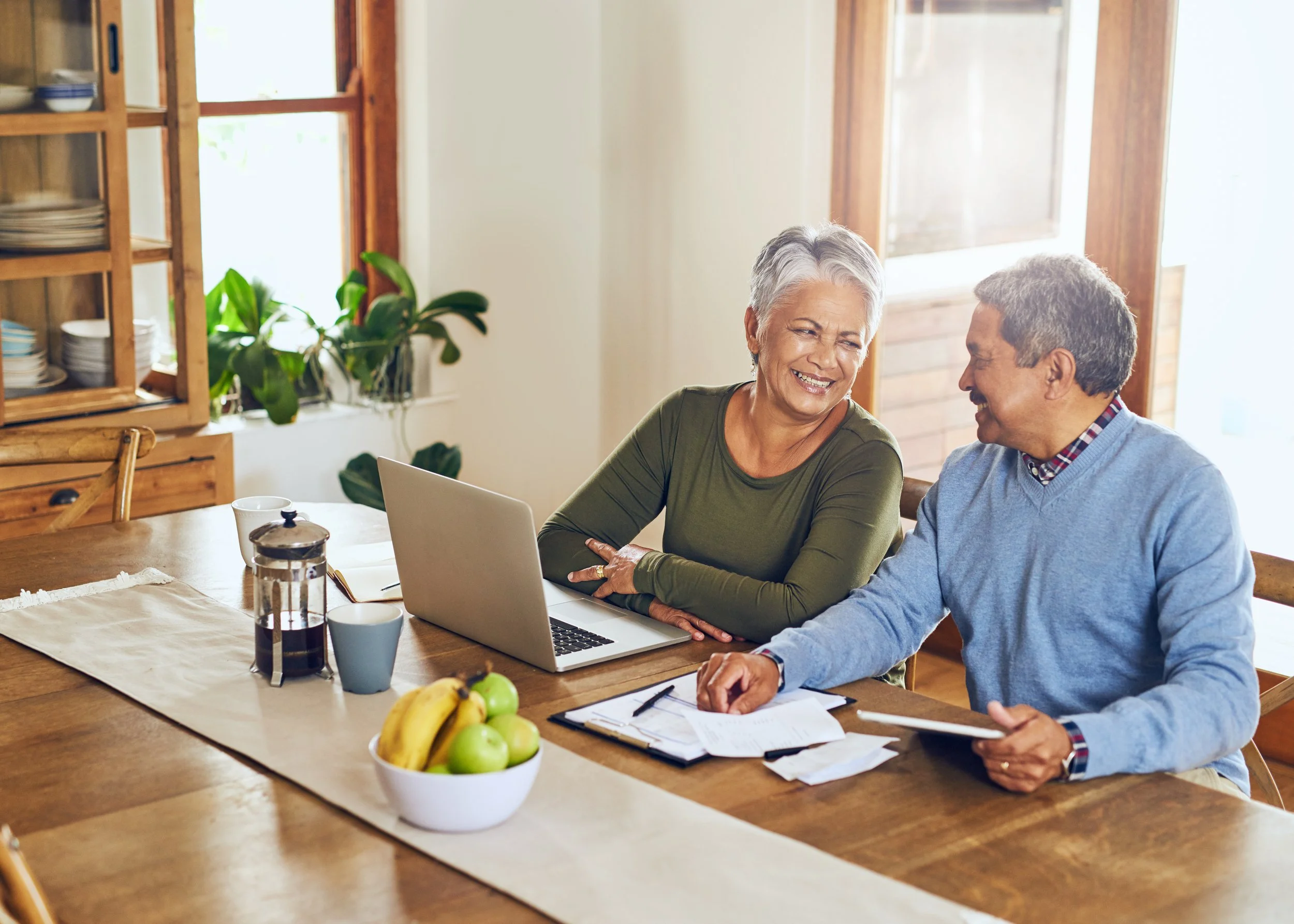 Couple in their sixties reviewing Medicare enrollment options together at home.