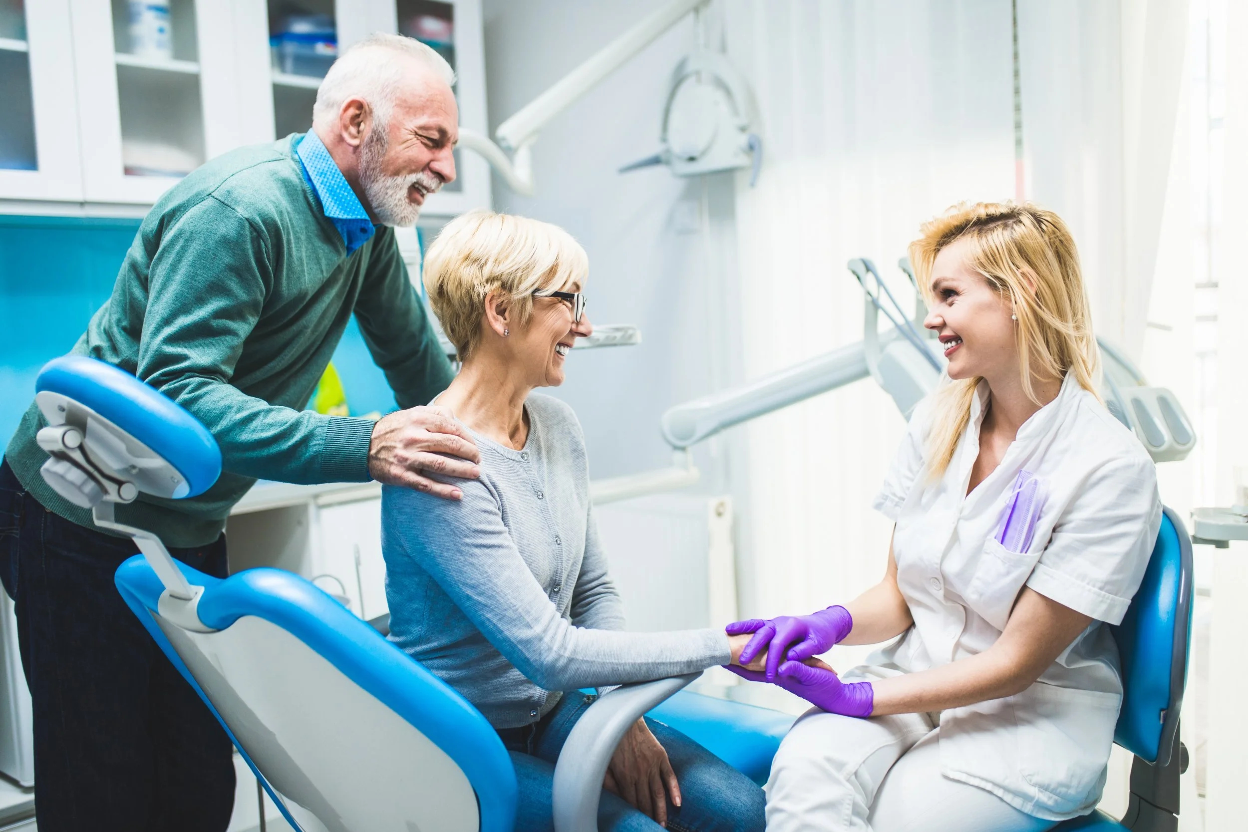 Senior couple at a dental and vision checkup smiling.